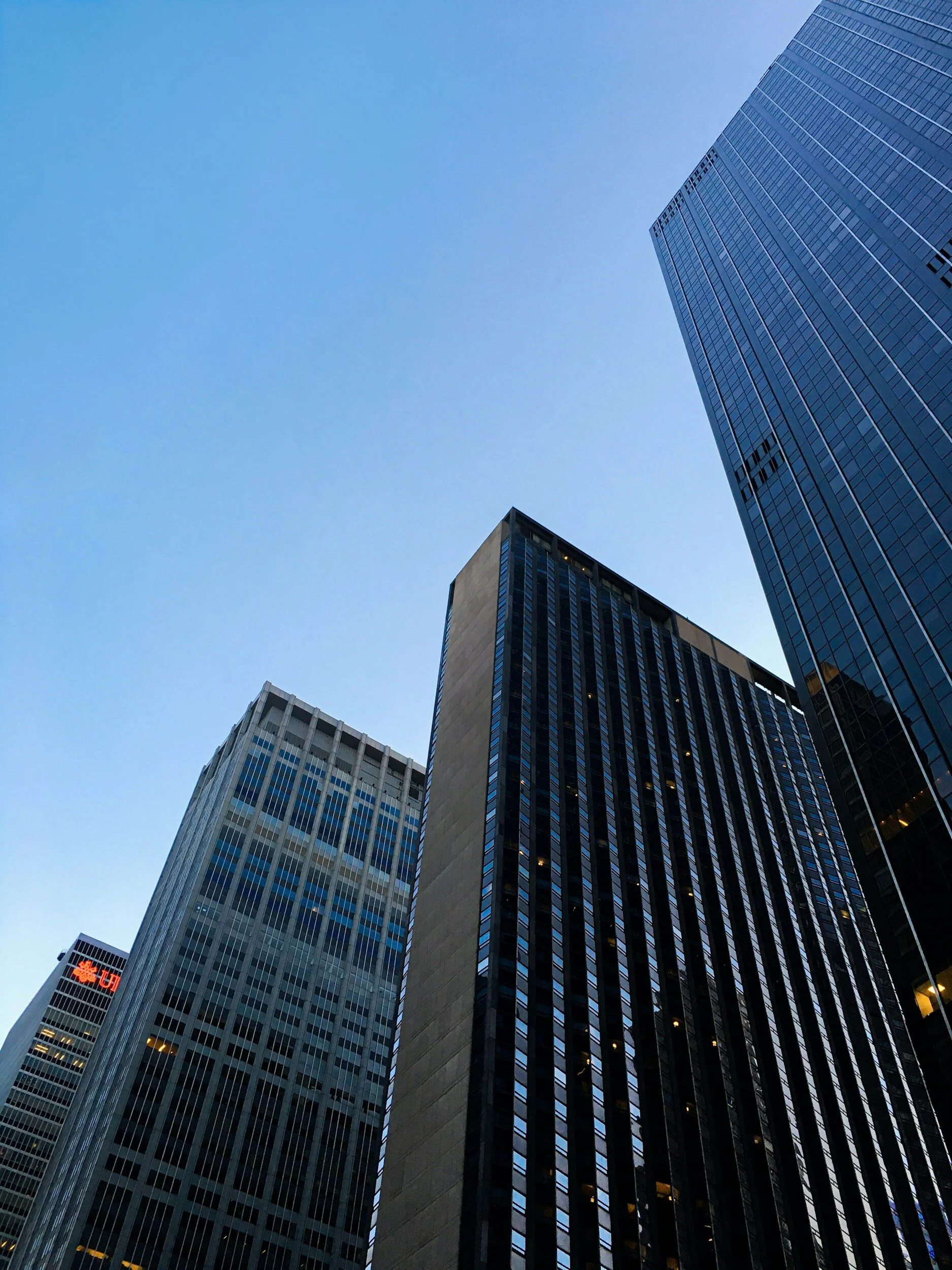 View of tall modern skyscrapers against a clear blue sky