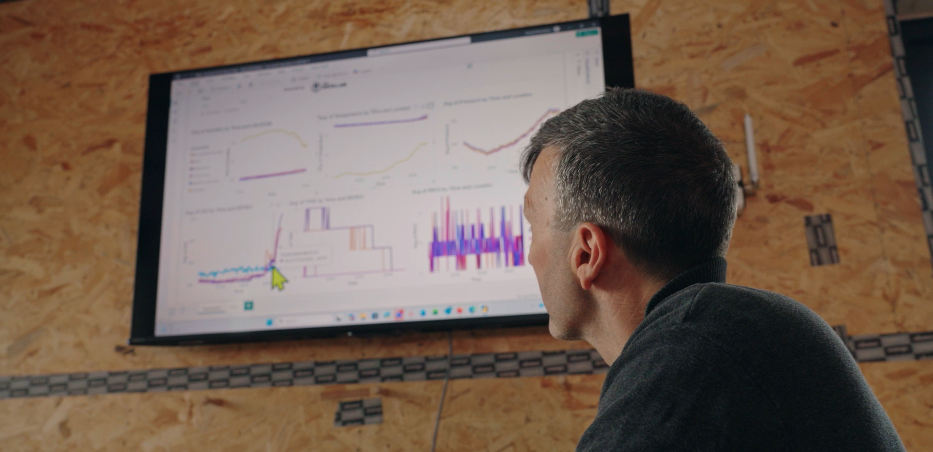 Close up Neil and graphs in background - screengrab.png