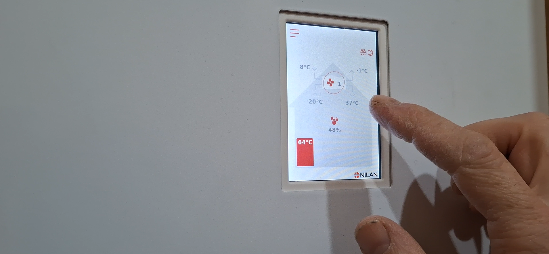 Close-up of a hand interacting with a digital control panel on a white appliance, showing temperature settings, humidity levels, and a brand logo.