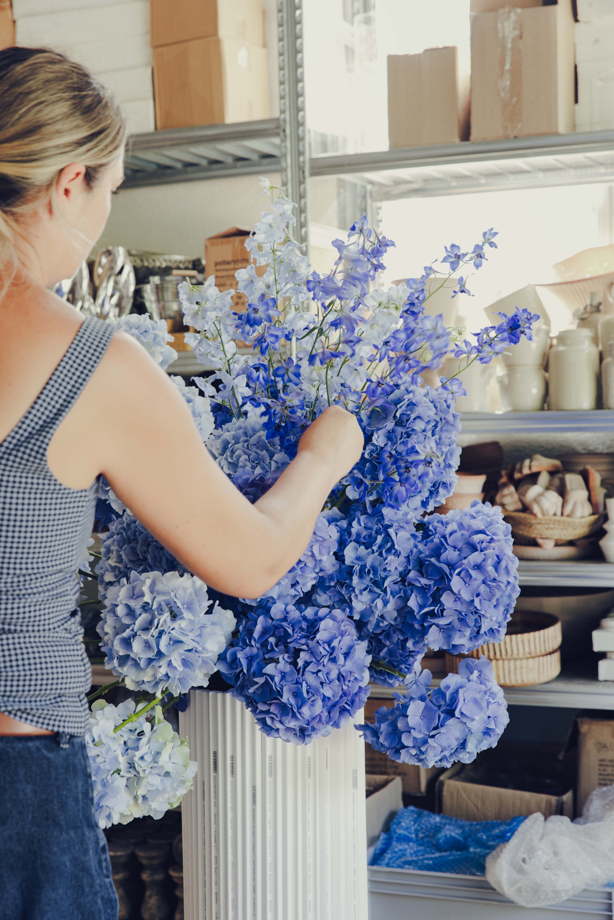 GRÖNT florist building a large blue hydrangea and delphinium arrangement in the studio