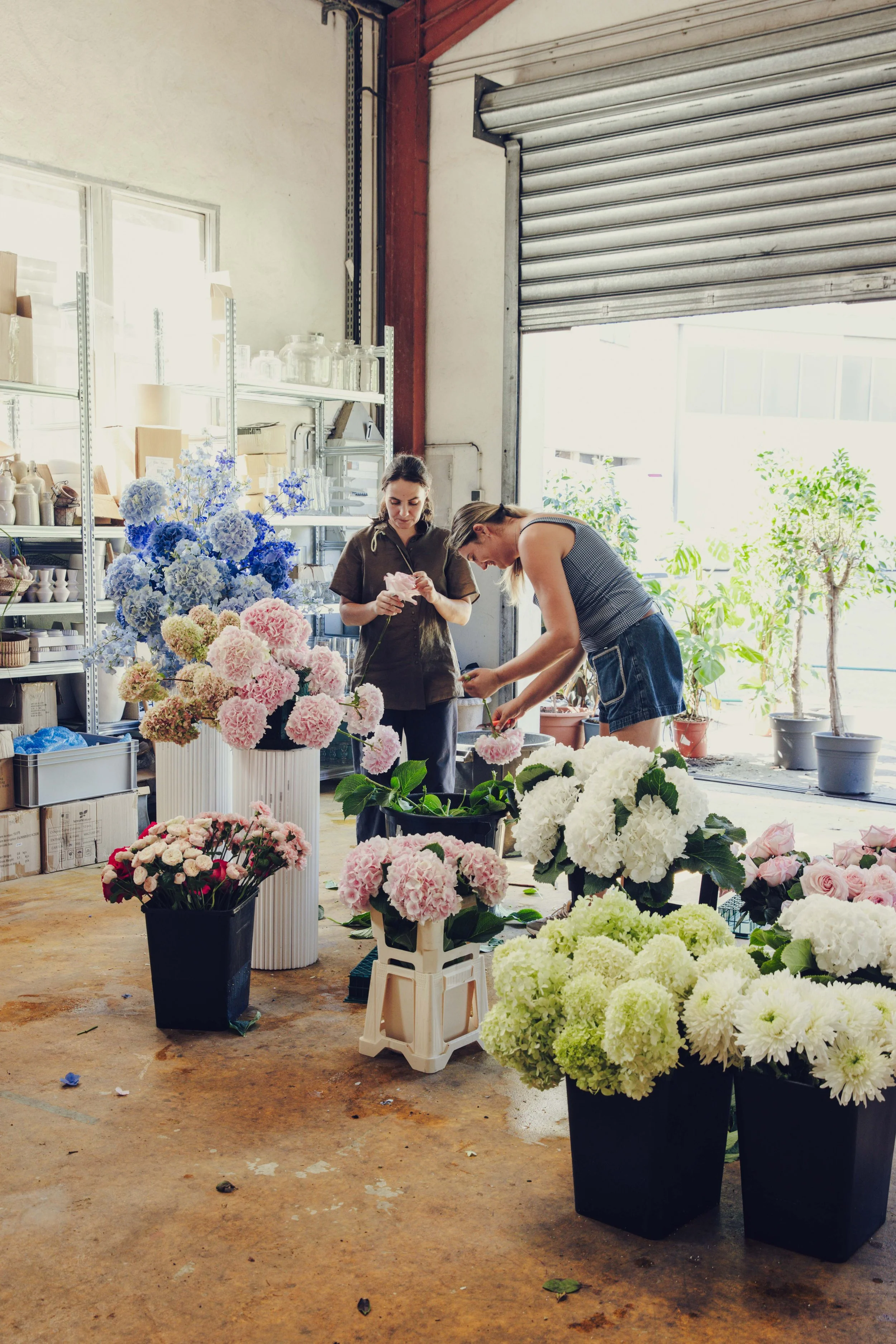 GRÖNT team preparing hydrangea arrangements among buckets of flowers in the Cannes studio
