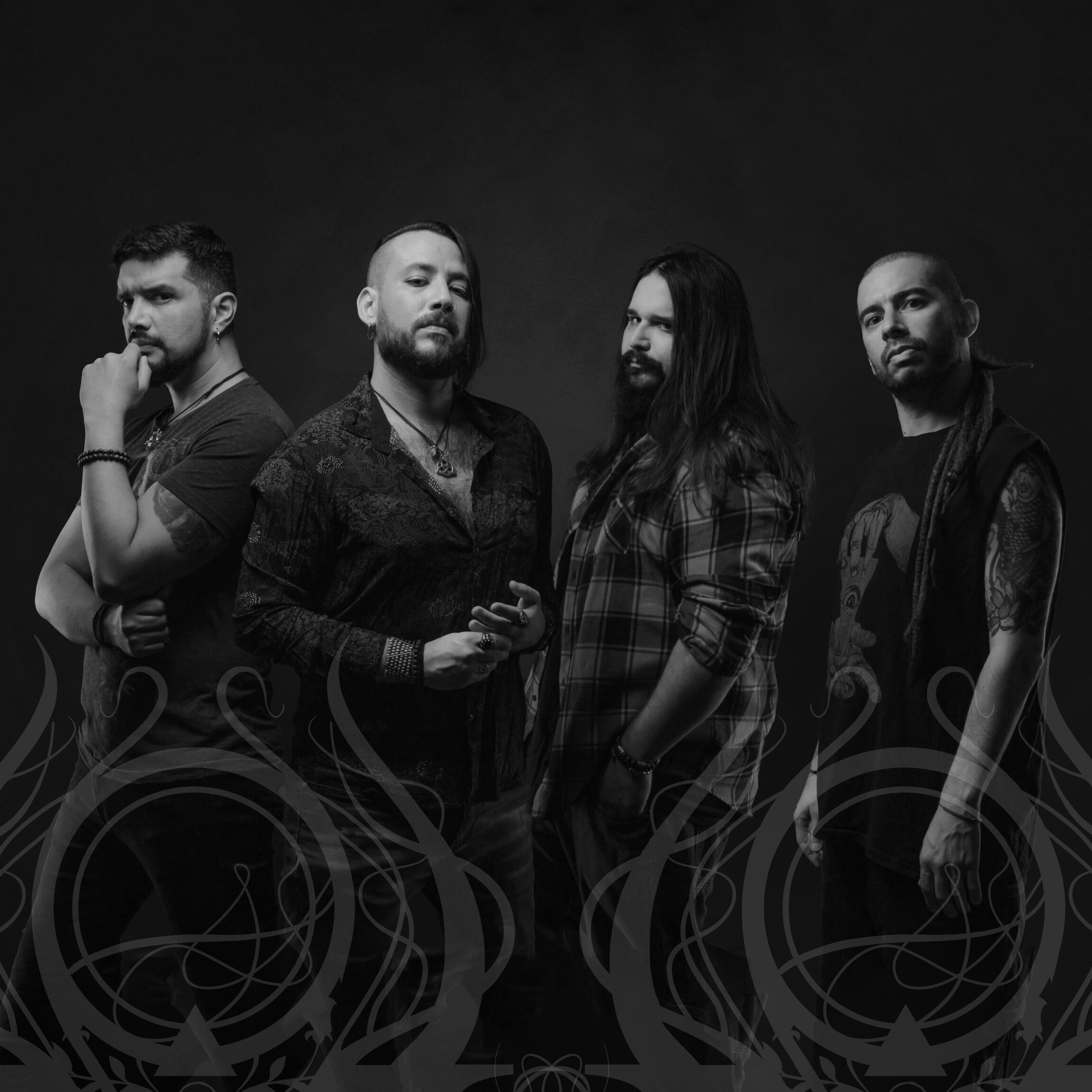 Group of four men posing confidently in black and white with artistic swirls at the bottom.