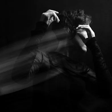 Abstract black and white photo of a person with hands raised, motion blur effect