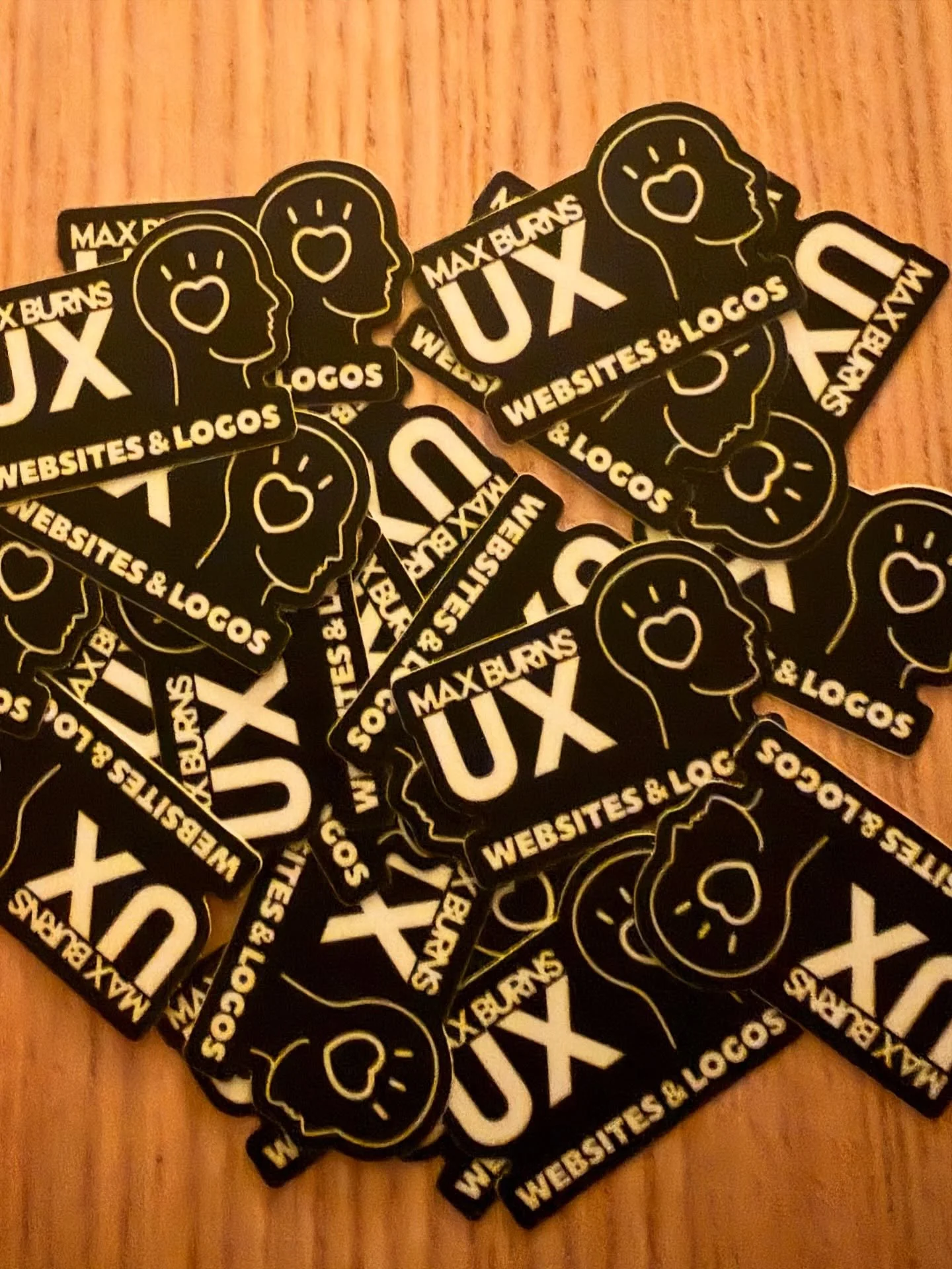 Who wants a sticker? 🤓💓

#QueerDesign #QueerWebsites #QueerLogos #QueerUX #SmalltownBoy

Image description: pile of max burns ux logo stickers sits on a light wooden table. The logo is white on a black background and is a side profile outline of a 