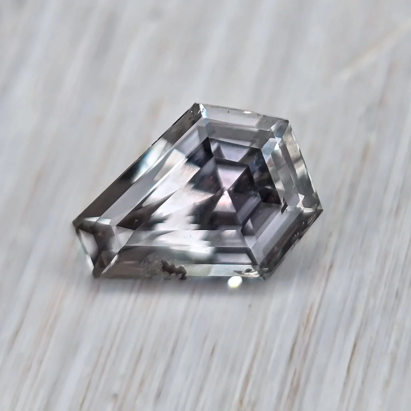 Unheated Montana Sapphire up for grabs! 🩶 1.3 ct, 7.5mm x 6mm, with spooky perfection for Halloween. ⚰️ Eye clean with minor corner inclusion under 10x. Stunning silver color and subtle lavender tones shine in a kite-coffin step cut. Very sparkly! ?