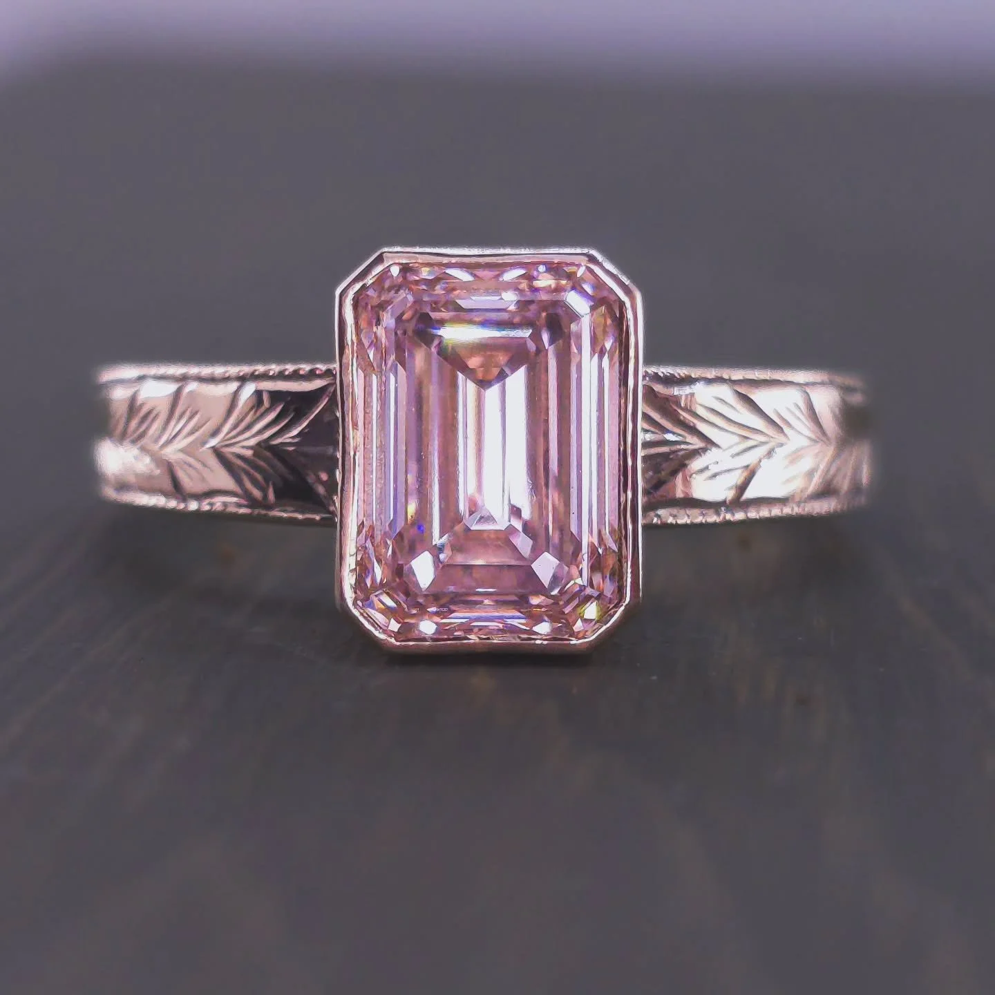 New arrival alert! This hand-engraved gold ring showcases a breathtaking Lab diamond, emerald cut, roughly available with ~2-2.1 ct VVS1 diamonds in Fancy Pink or White. Natural diamonds are also available.The intricate leaf design and open bezel set