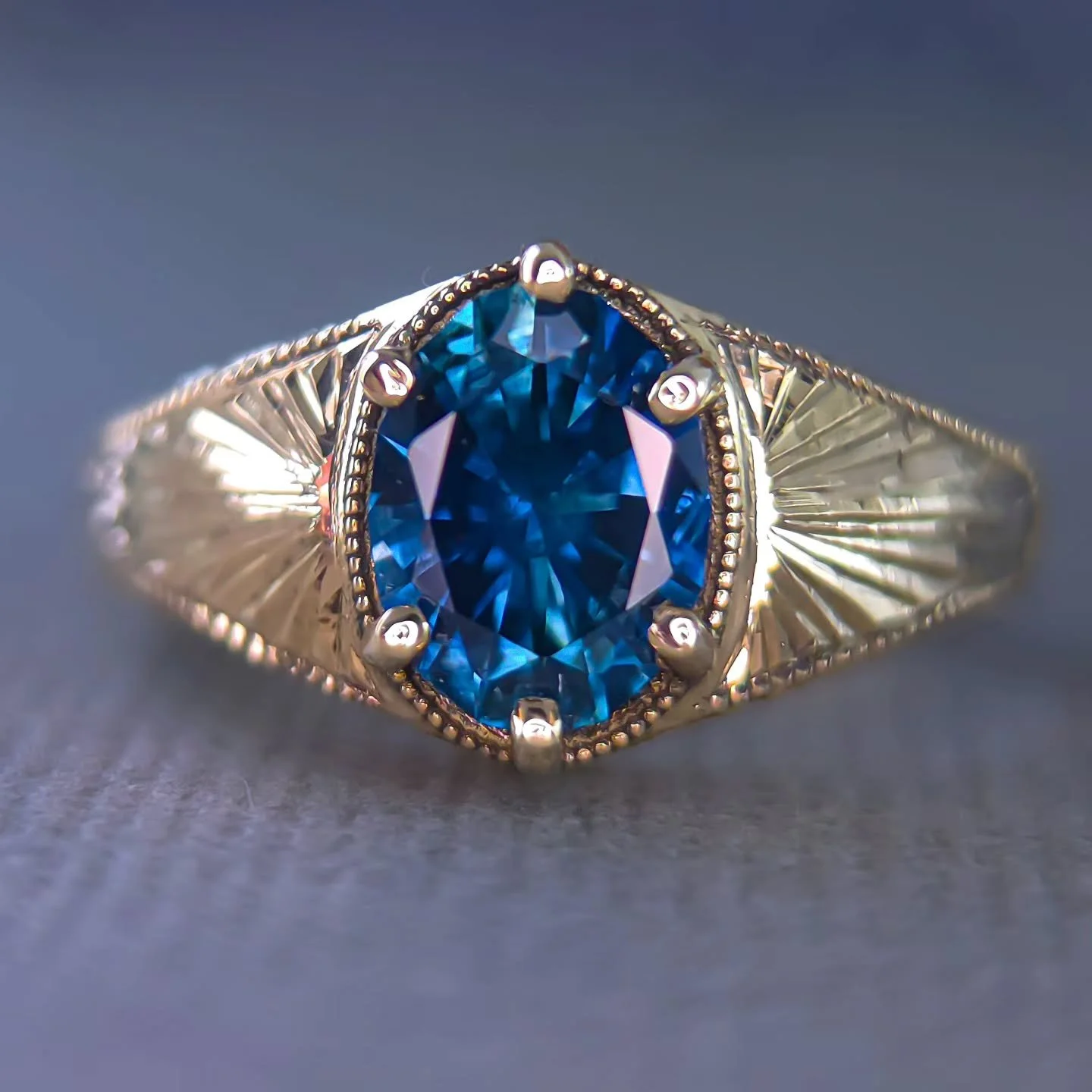 18kt yellow gold custom ring for a client. 1.9 ct Montana sapphire, heated, Rock Creek origin - this project was a dream to work on. The engraved rays are meant to draw the eye to the sapphire, a simple but regal style that shimmers in the sun. This 