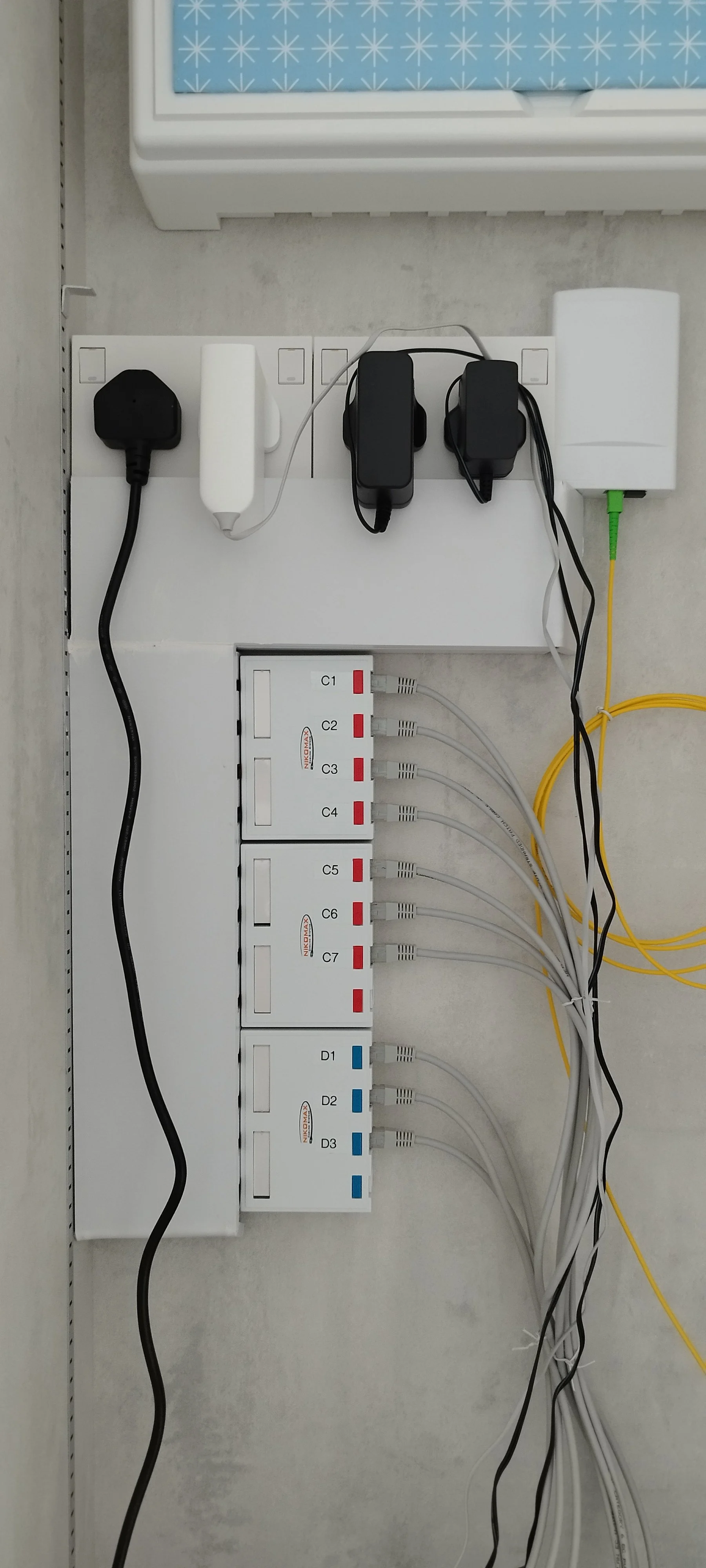 Electrical panel with multiple colored wires connected to labeled ports and power adapters.