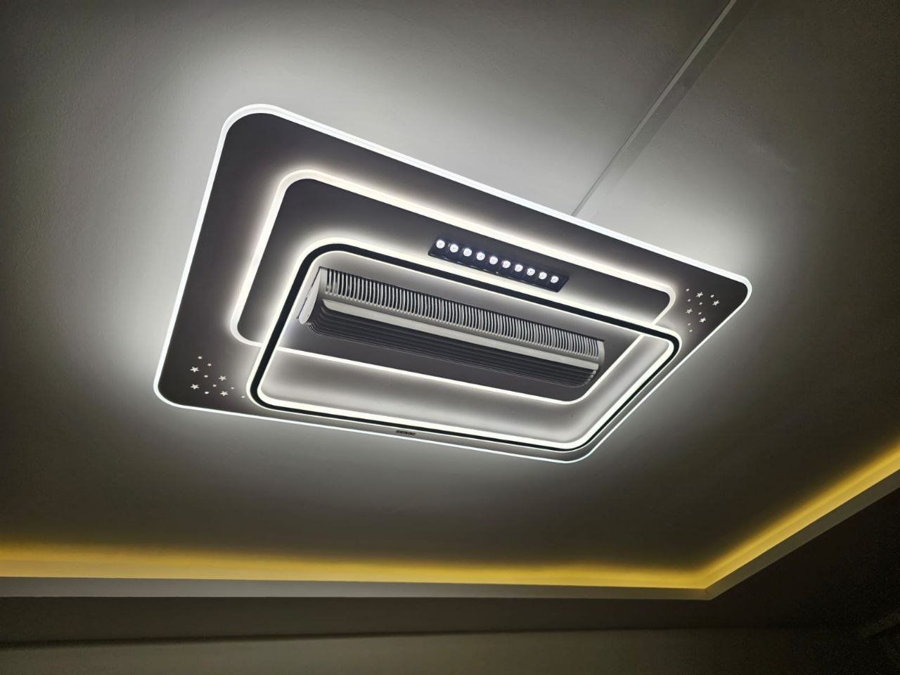 Modern ceiling air conditioning unit with LED lighting and decorative stars, installed in a ceiling with a cove lighting feature.