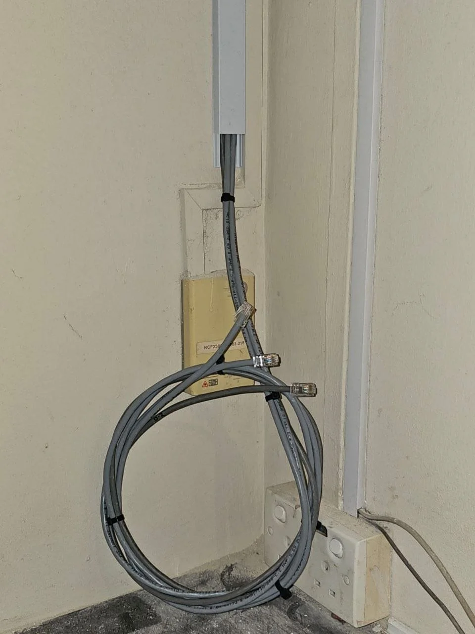 Electrical wires and cables near a wall and power outlets.