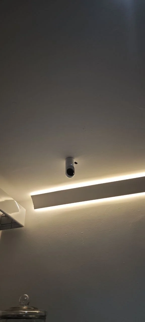 Ceiling with a security camera and LED strip lighting.