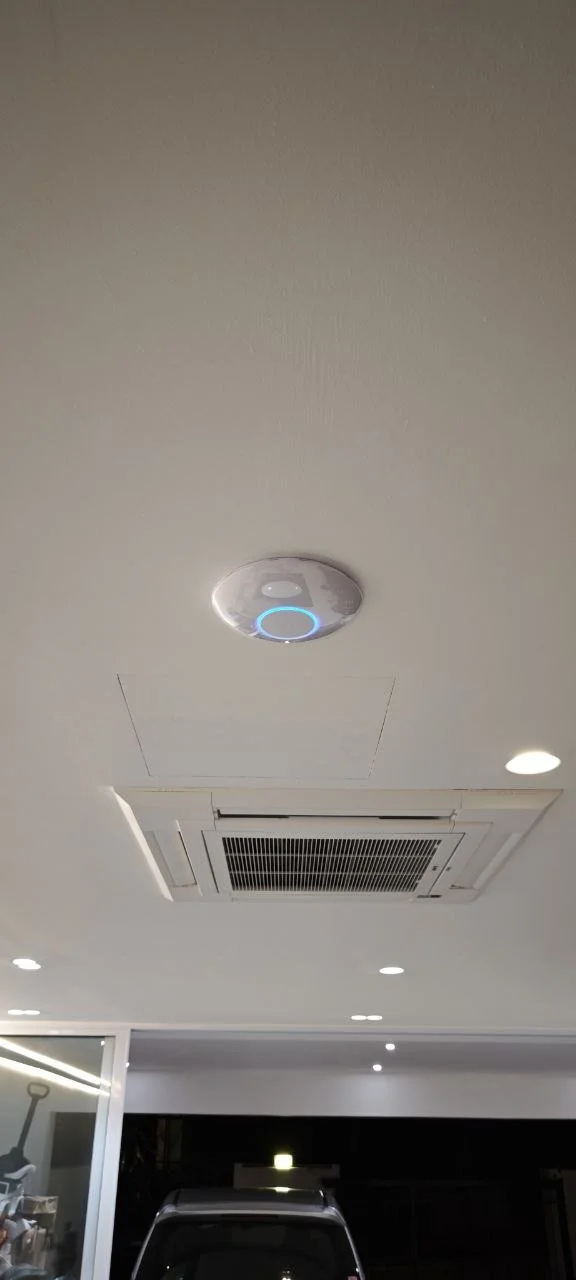 Ceiling with built-in air conditioning vent, ceiling lights, and a smoke detector with an illuminated blue ring.