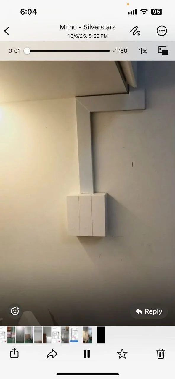 View of a corner with a white wall, a beige wall, and a white electrical box with a conduit pipe.