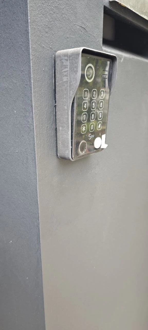 Electronic keypad lock mounted on a gray wall, likely used for secure entry.