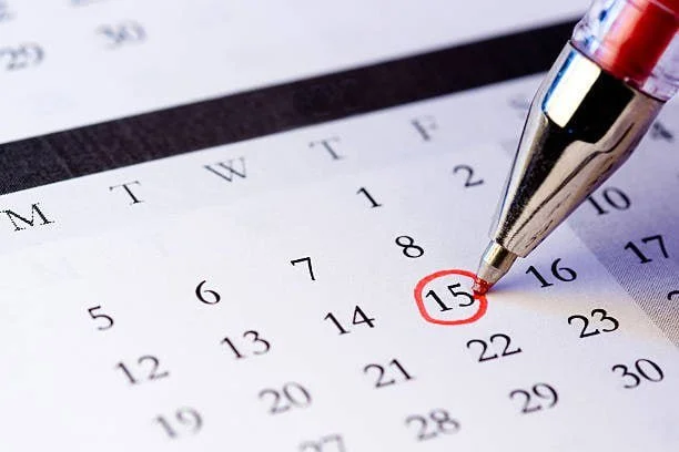 A pen marking the date 15 on a calendar.
