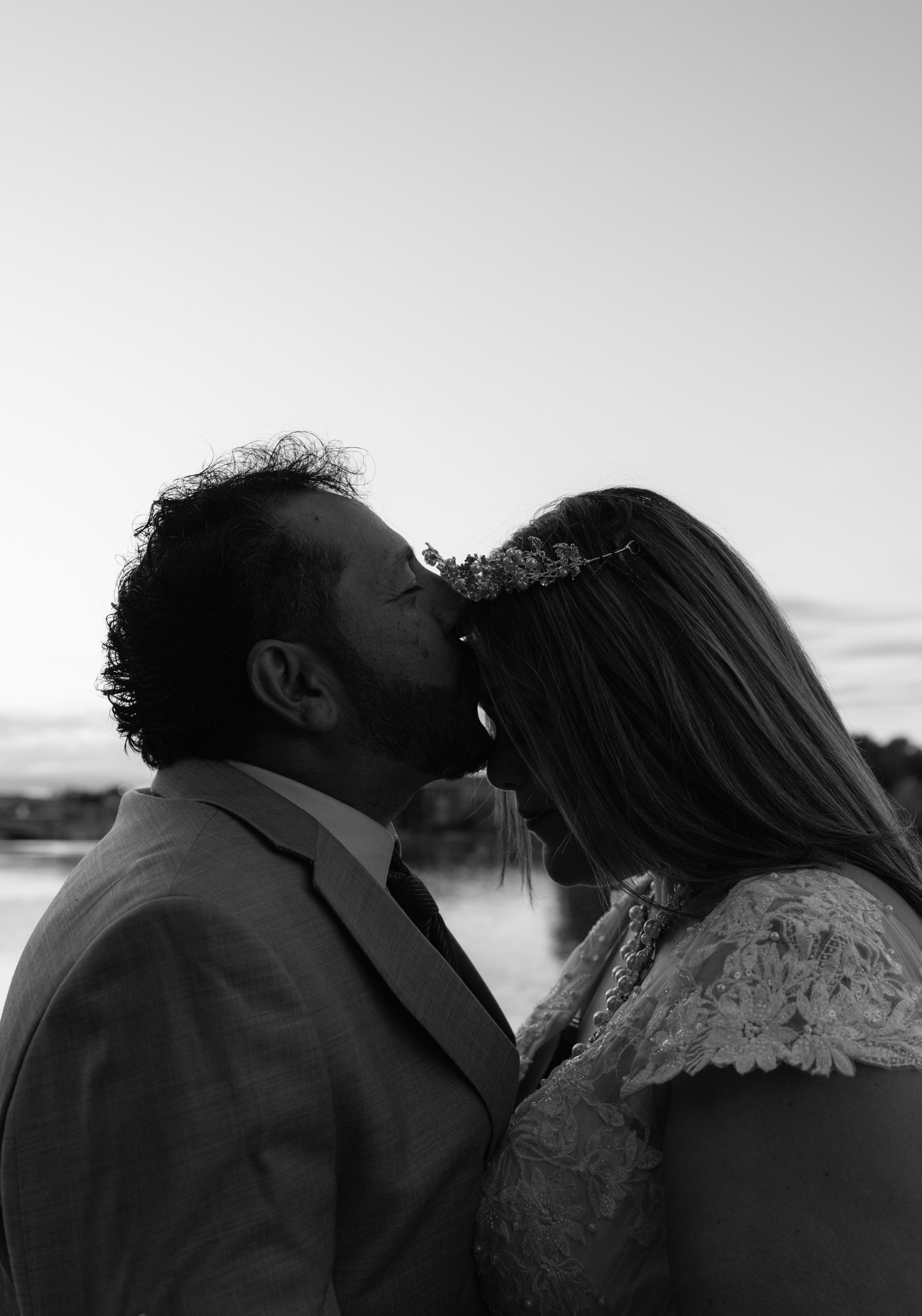 groom kissing the forehead of the bride in black and white after wedding in Neenah wisconsin