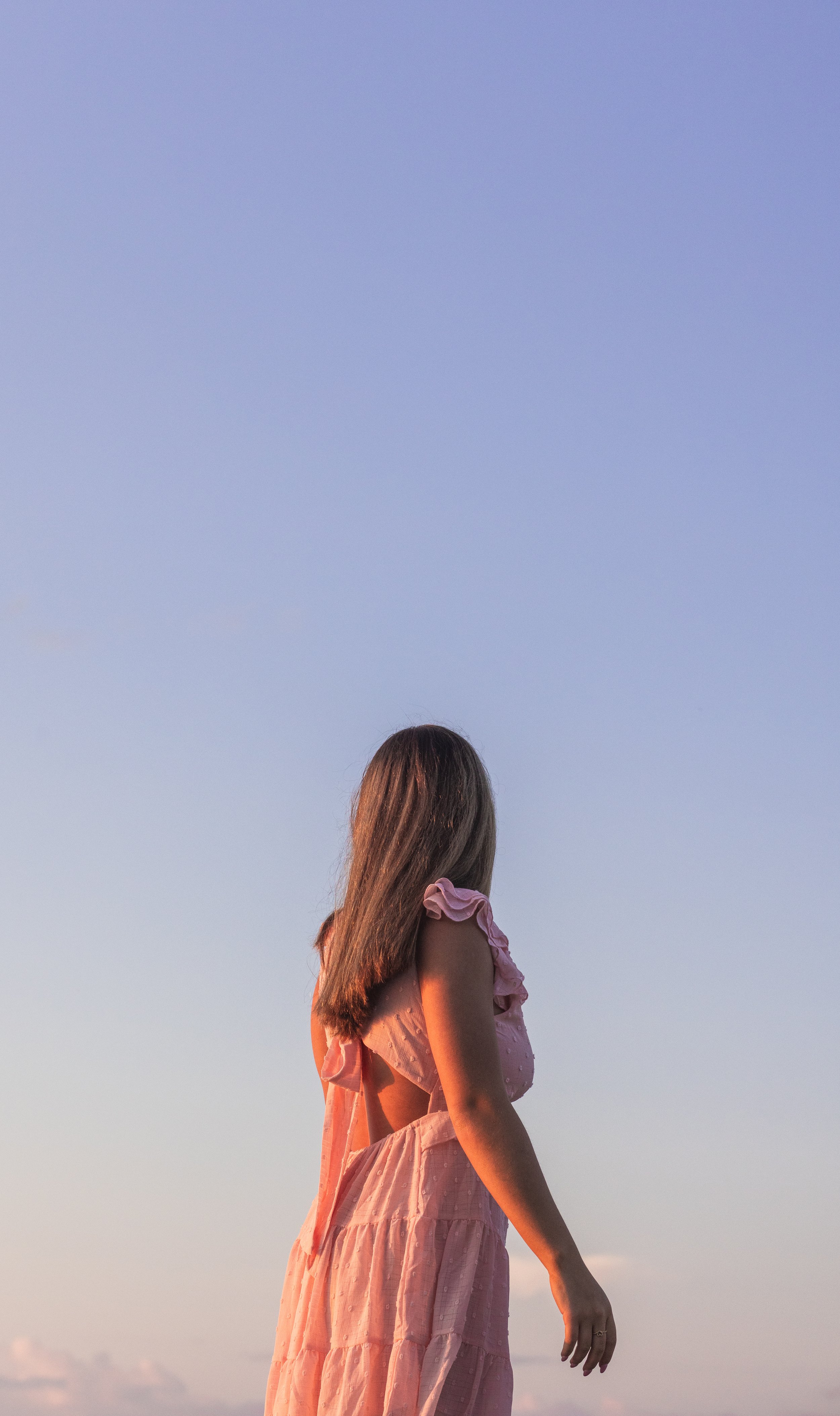 senior picture of girl looking away as the sunset glows up her skin