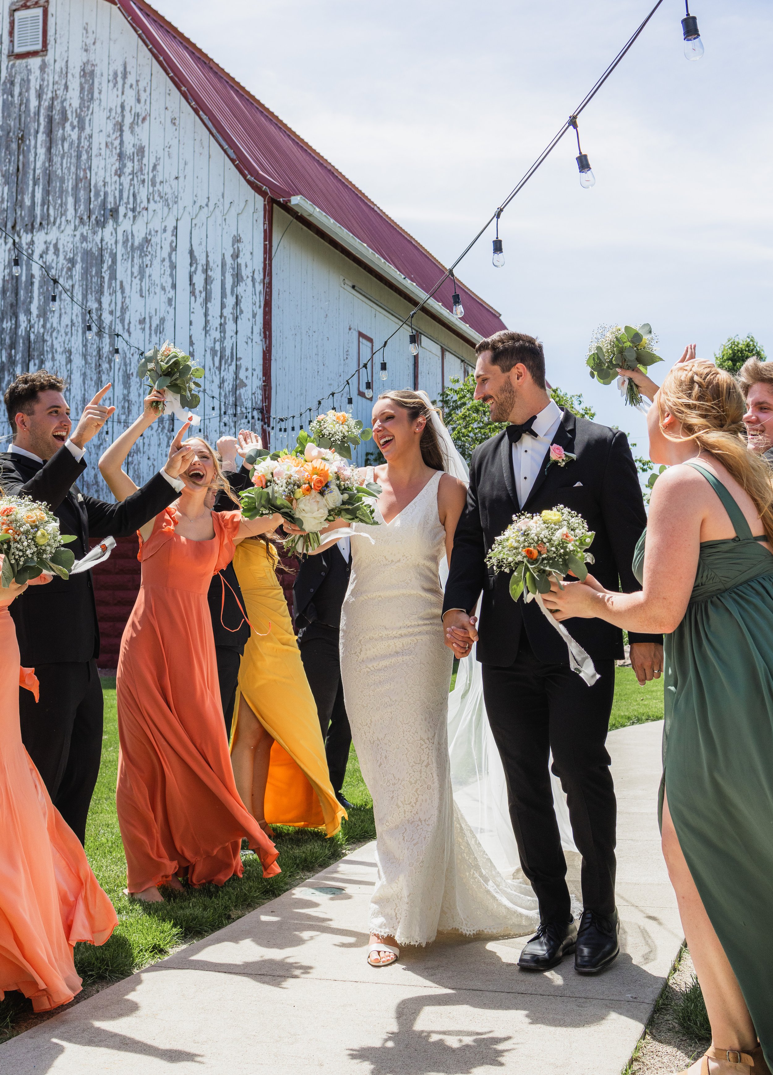 picture of bride and groom walking through their groomsmen and bridesmaids cheering them on