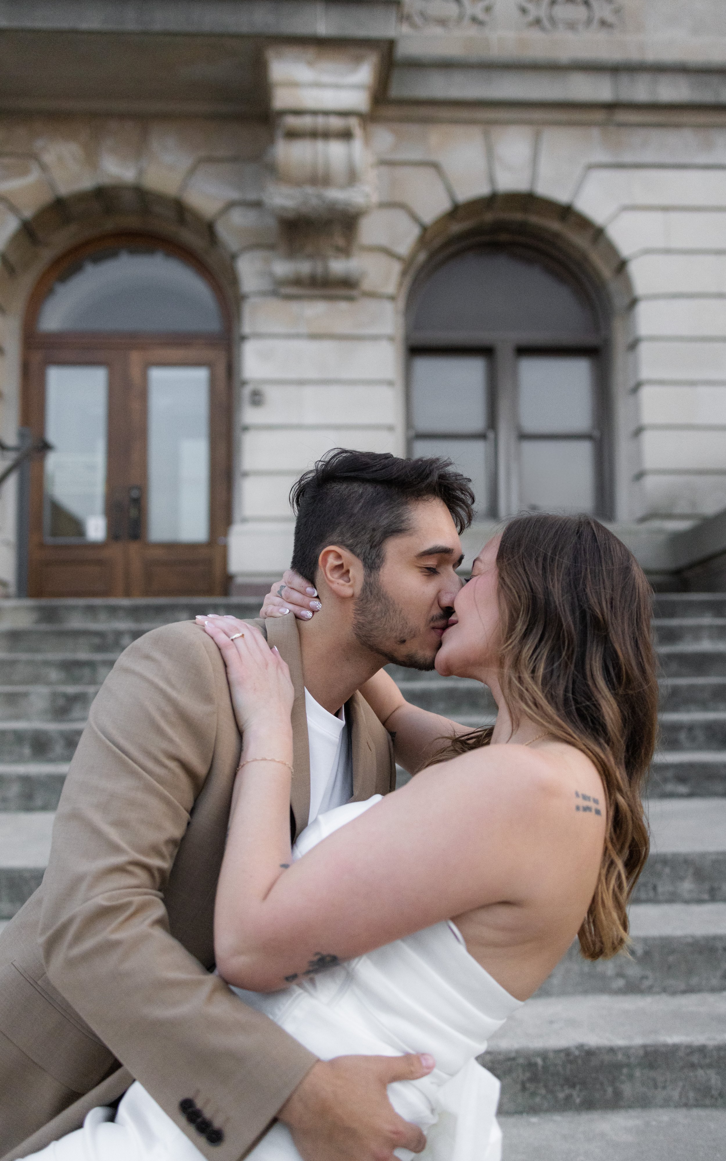 picture of just married couple kissing in front of the court house