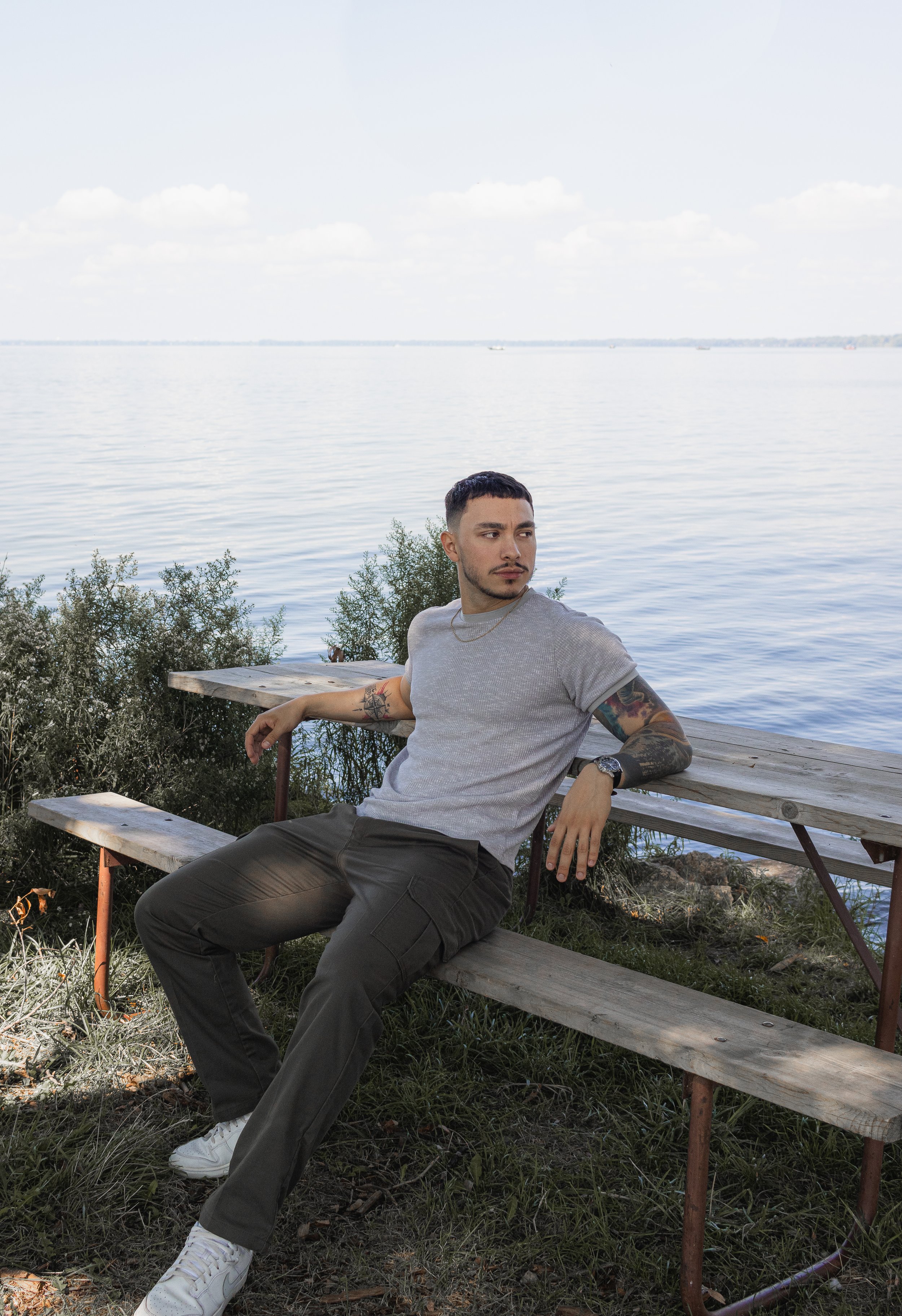 moody photo of man sitting on a bench in high cliff state park