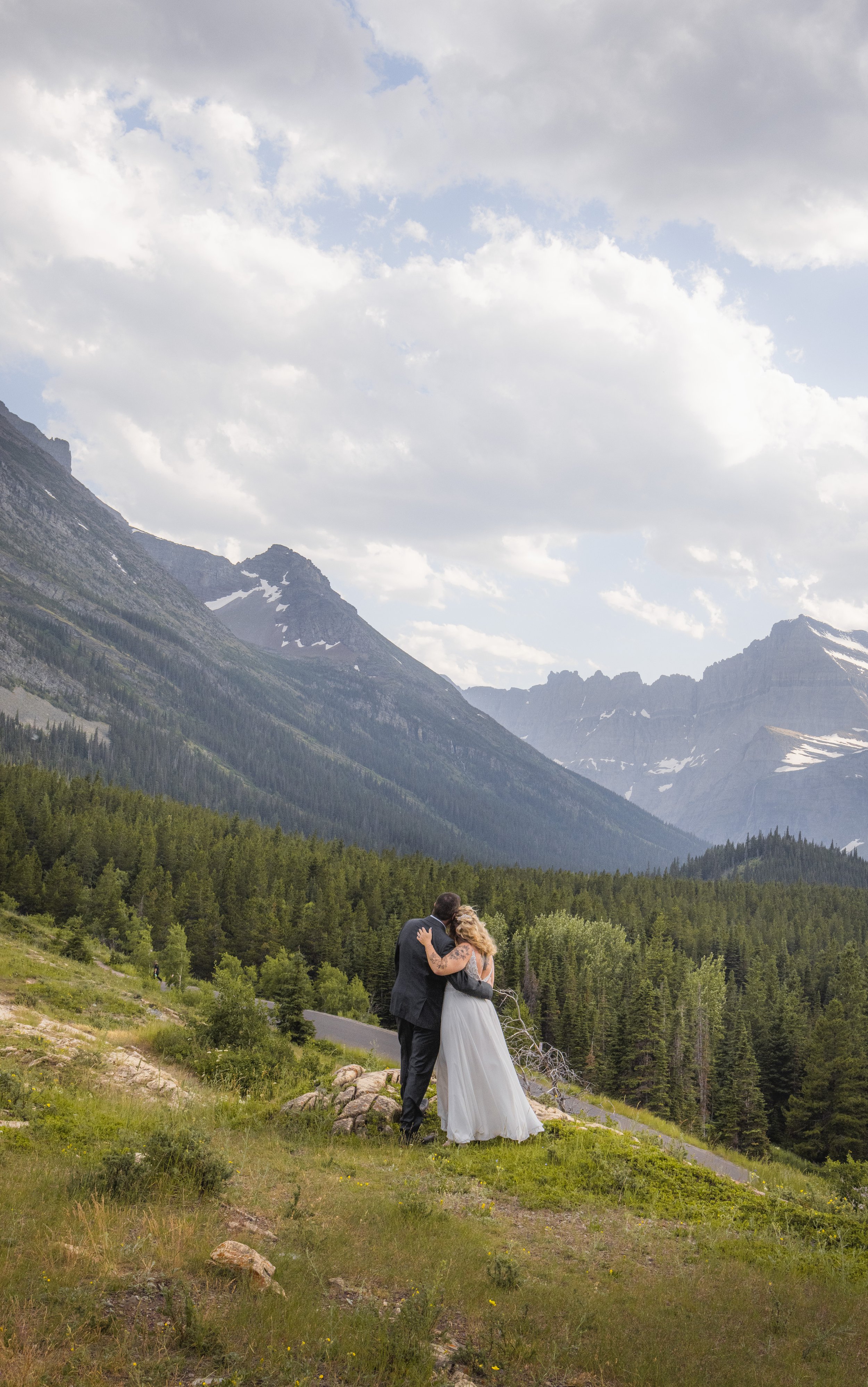 picture of couple facing the beautfiul glacier park mountains