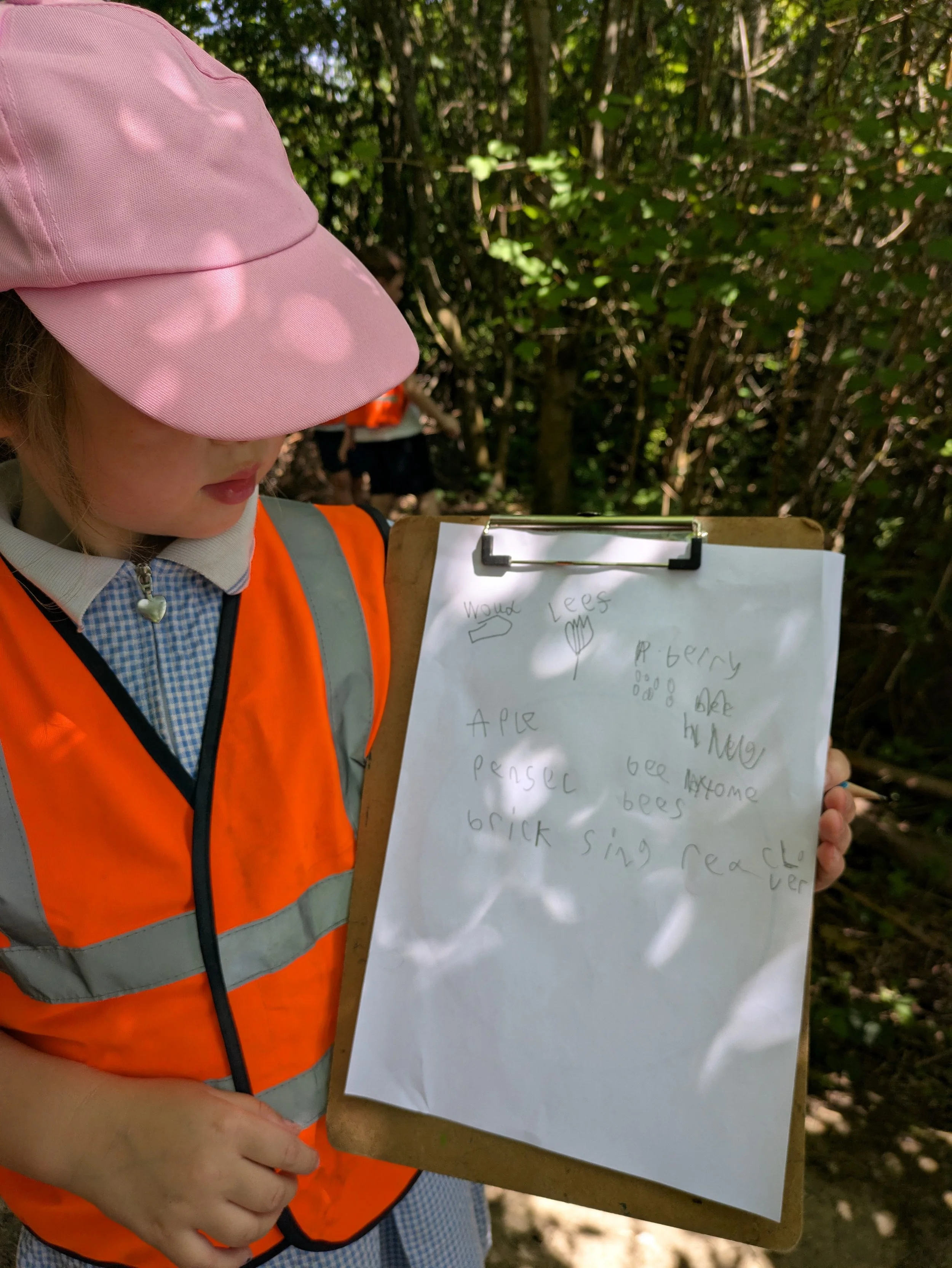 Photo of child with clipboard and nature record