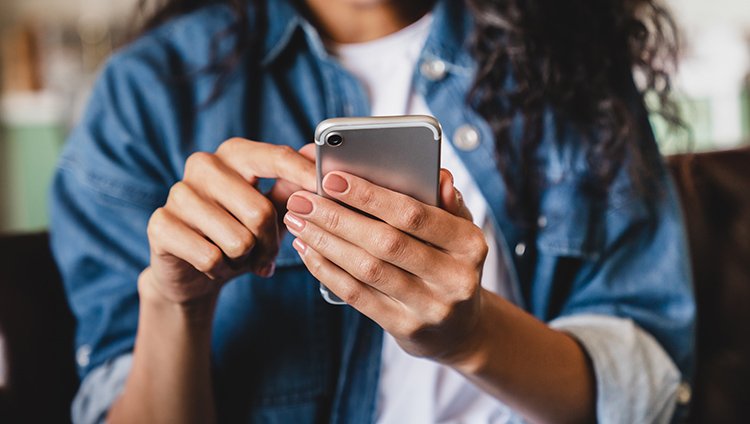 Close-up of a person using a smartphone, emphasizing digital communication and online safety practices.
