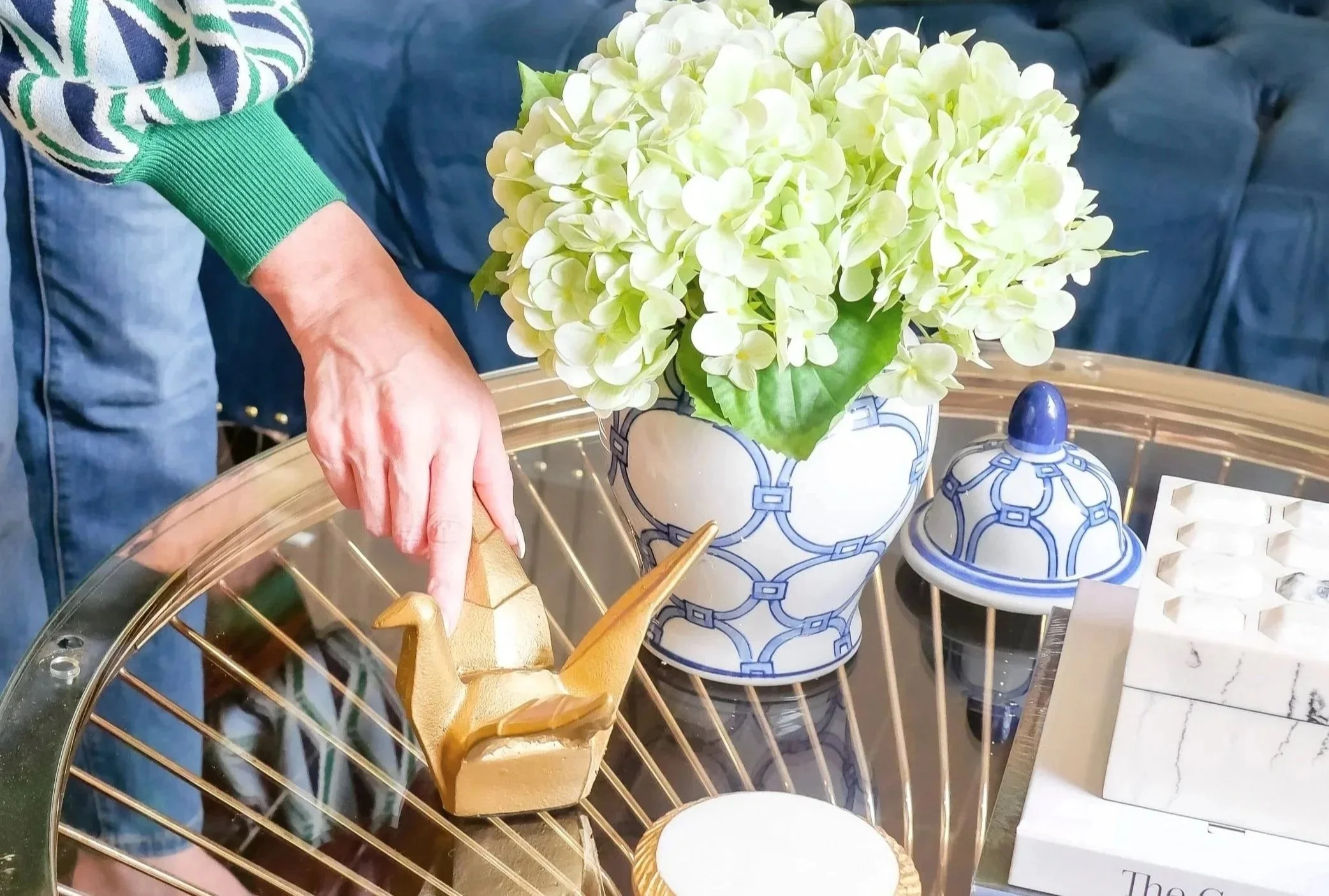 Interior designer styling a coffee table with decorative accessories.