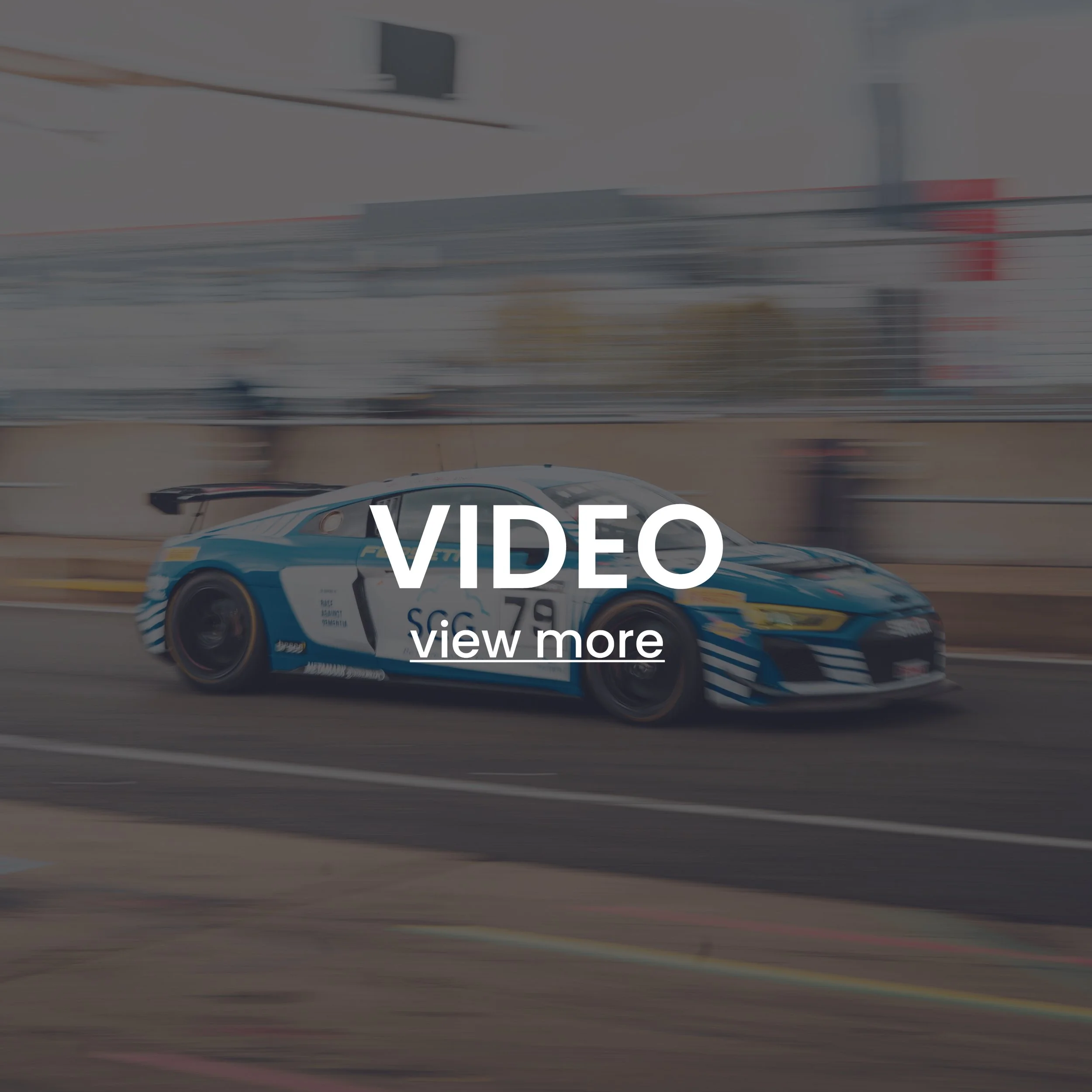 Blurred motion image of a race car on a track with text overlay "VIDEO view more."