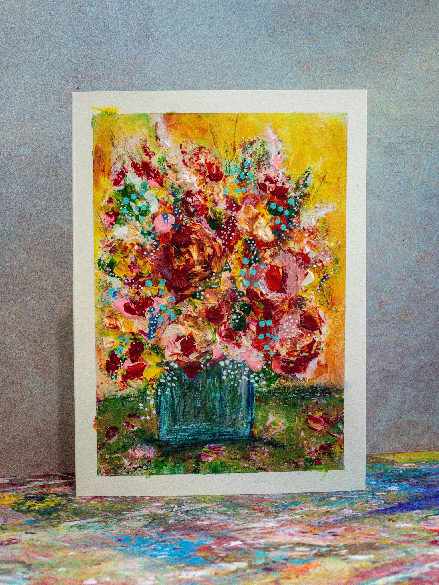 A colorful abstract painting of a flower vase with a bouquet, standing on a vibrant multicolored surface.