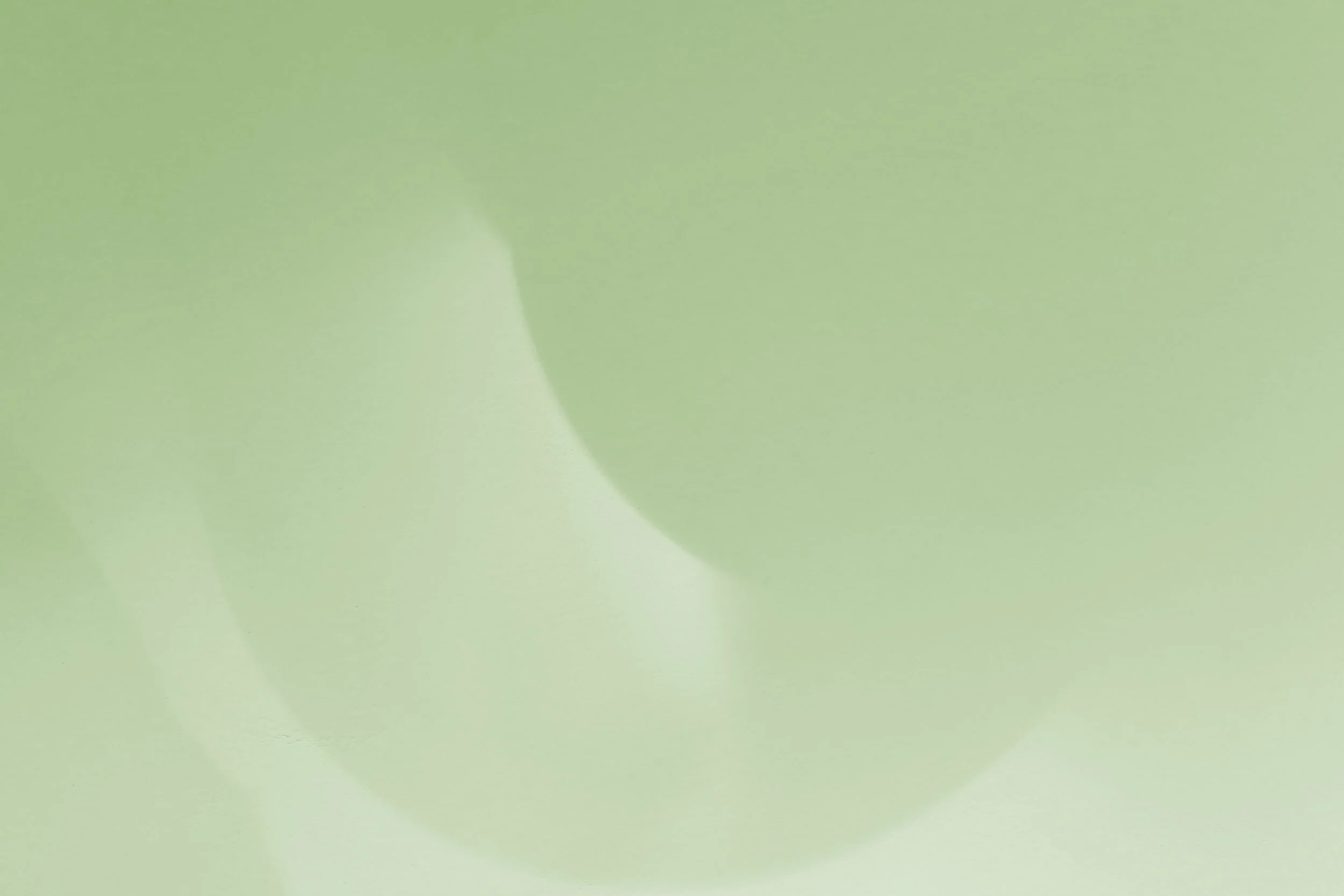 Close-up of a green apple with a leaf attached.
