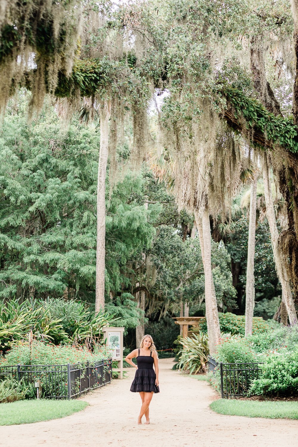 senior pictures under moss trees in Florida gardens