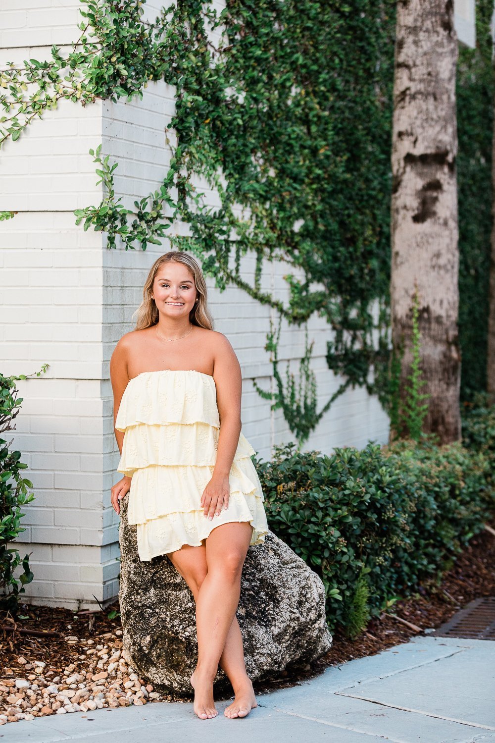 Senior pictures by a white brick wall, summer picture ideas in Ponte Vedra, FL