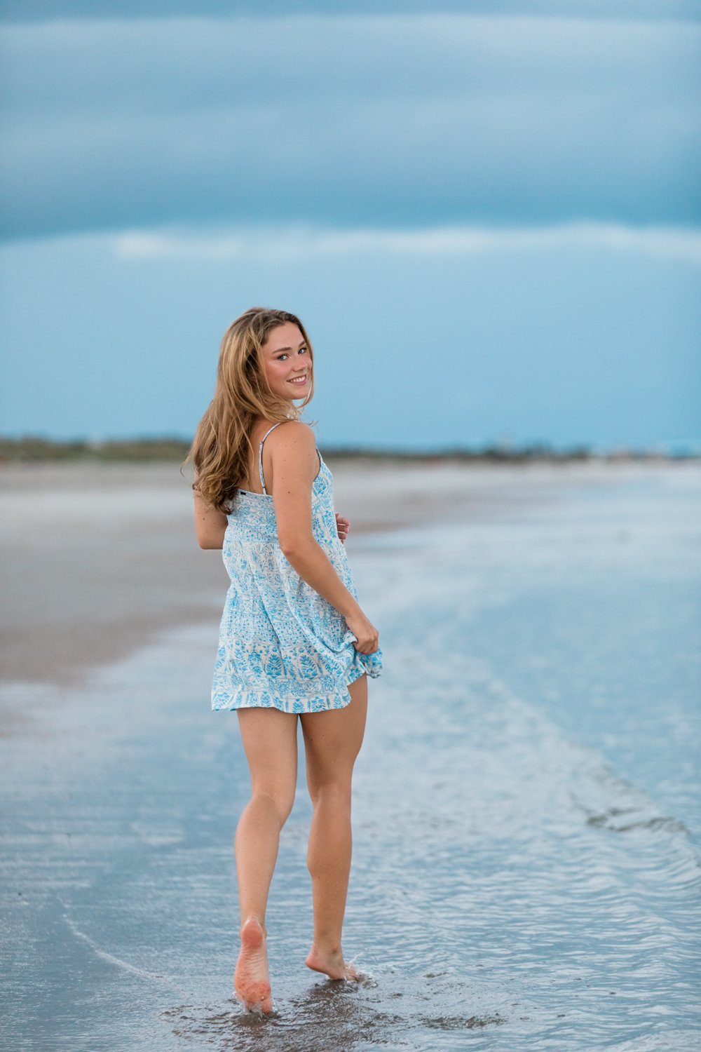 Senior girl running in the beach when storms are rolling in, Jacksonville FL