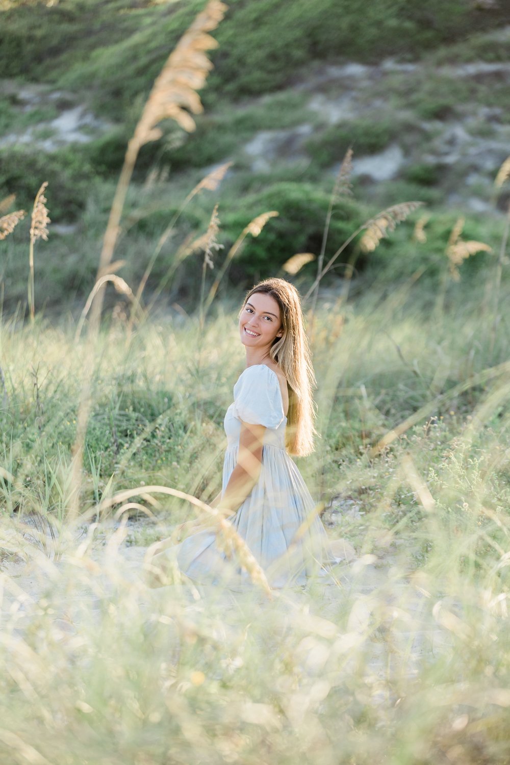 Senior pictures at the beach in a grassy greenery in Jacksonville Beach FL