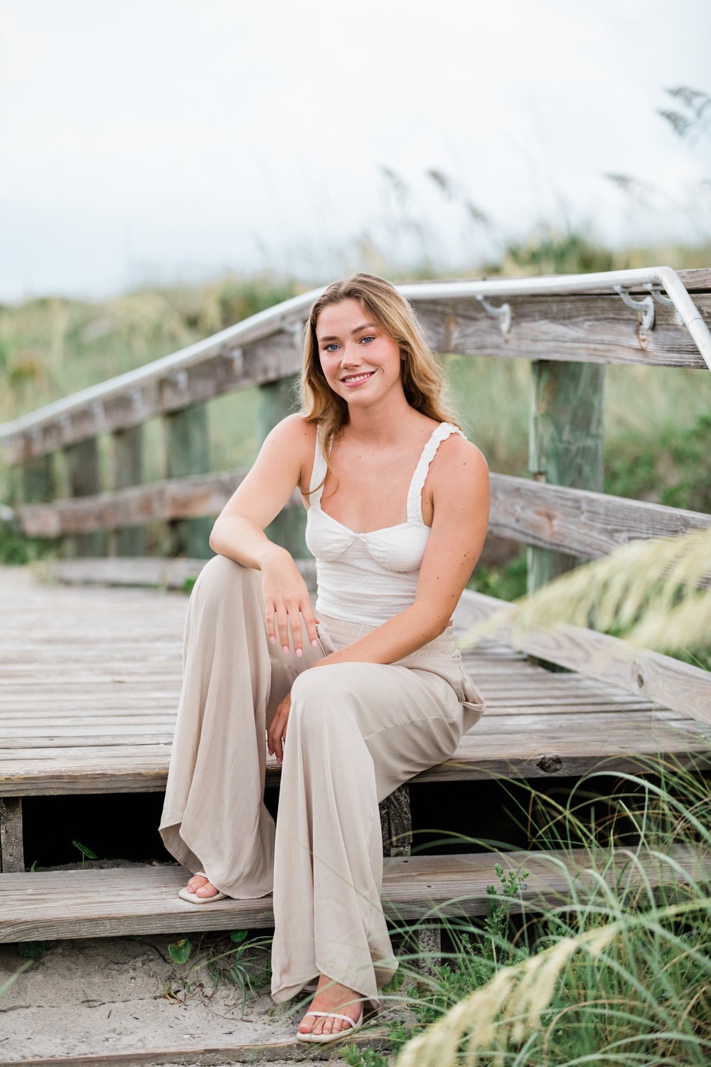 Senior girl sitting on the boardwalk at the beach in Jacksonville FL