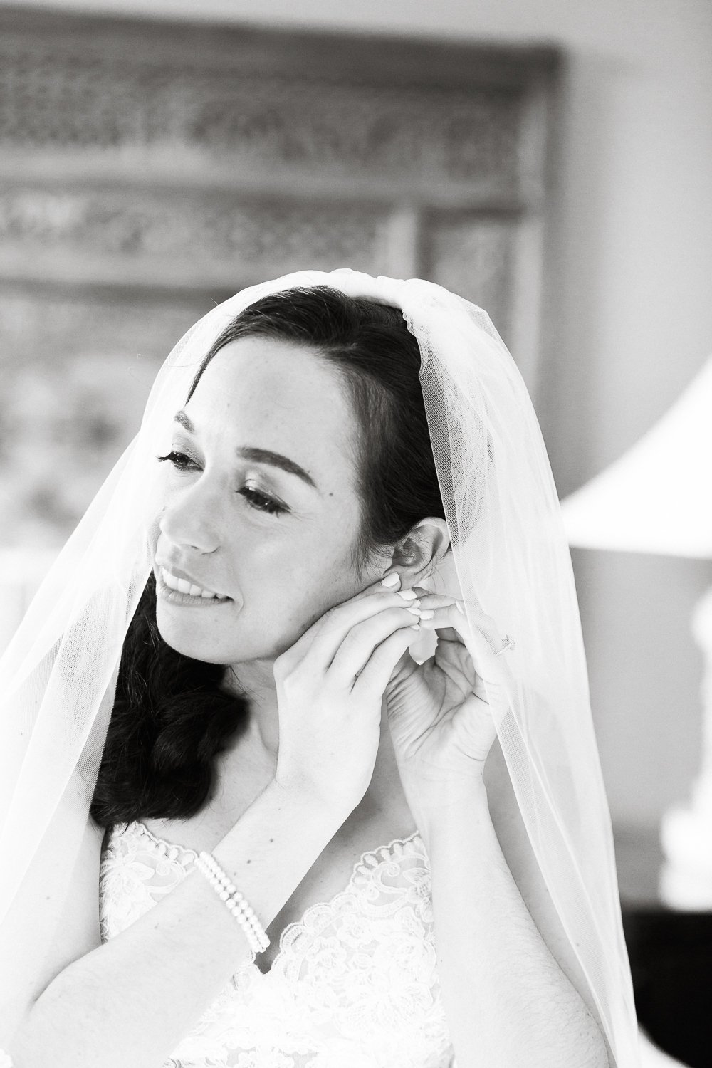 bride putting earrings on