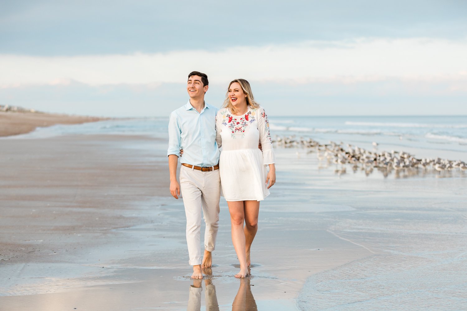 engagemet couple walking at the beach