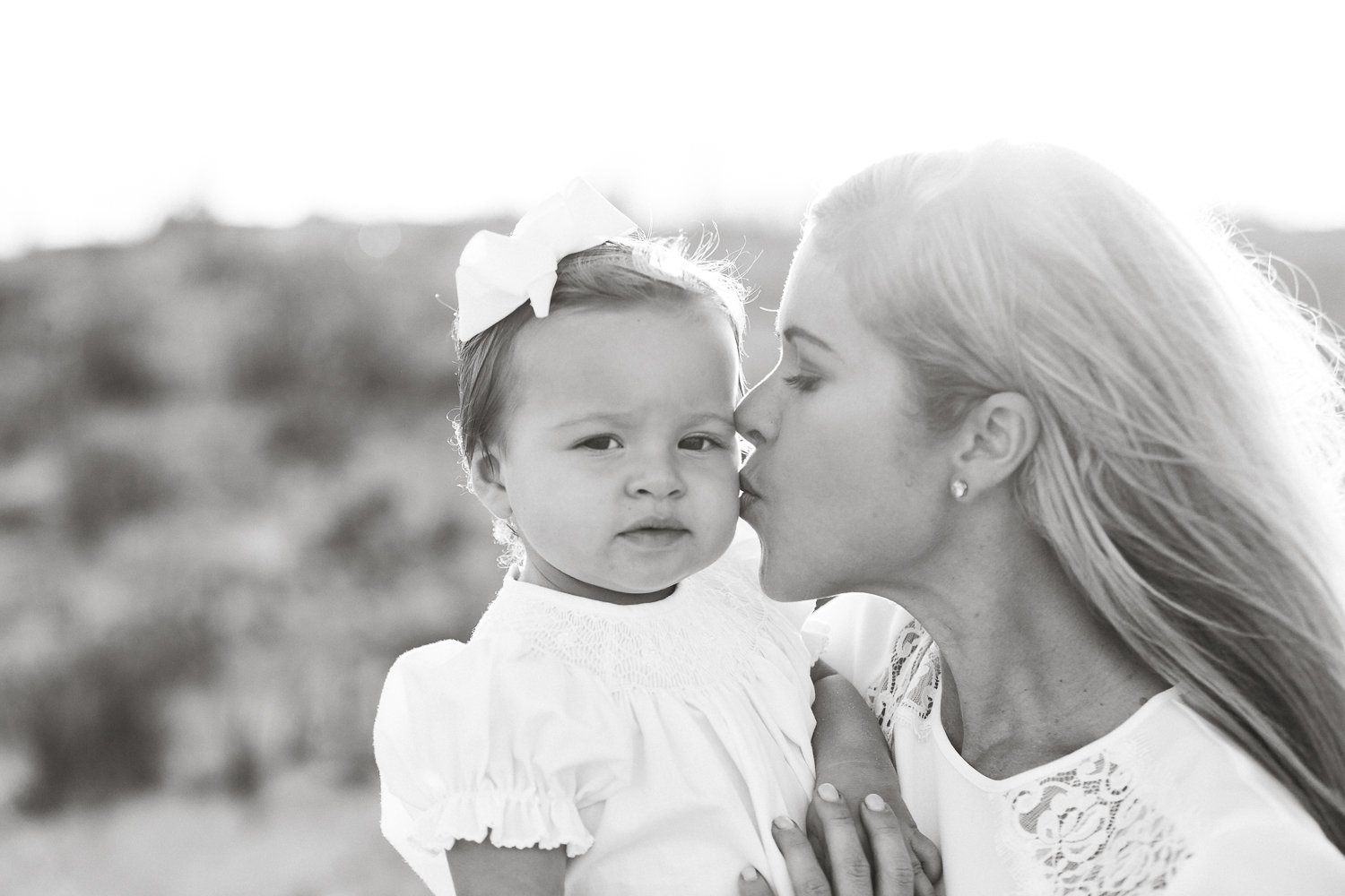 mommy kissing her baby girl during family session