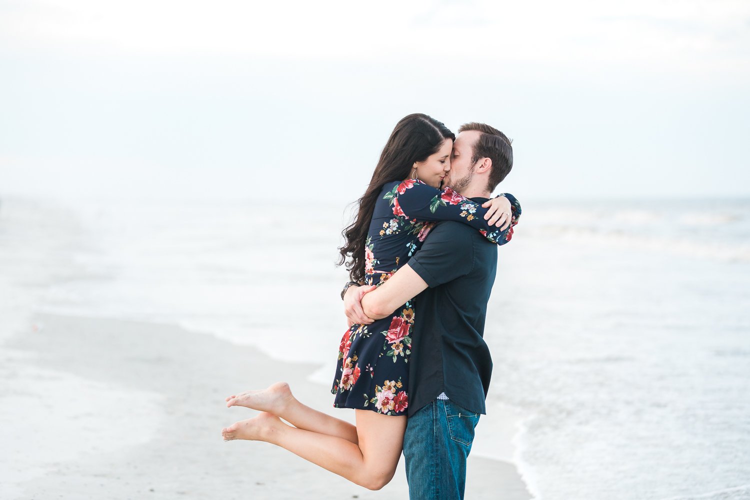 couple kissing at the beach during engagement pictures