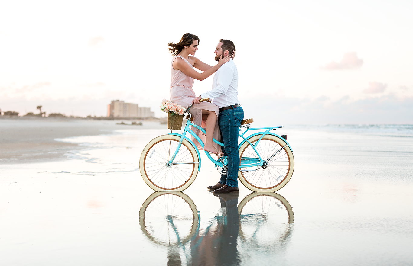 engagement pictures at the beach with a bike at sunset and basket filled with roses