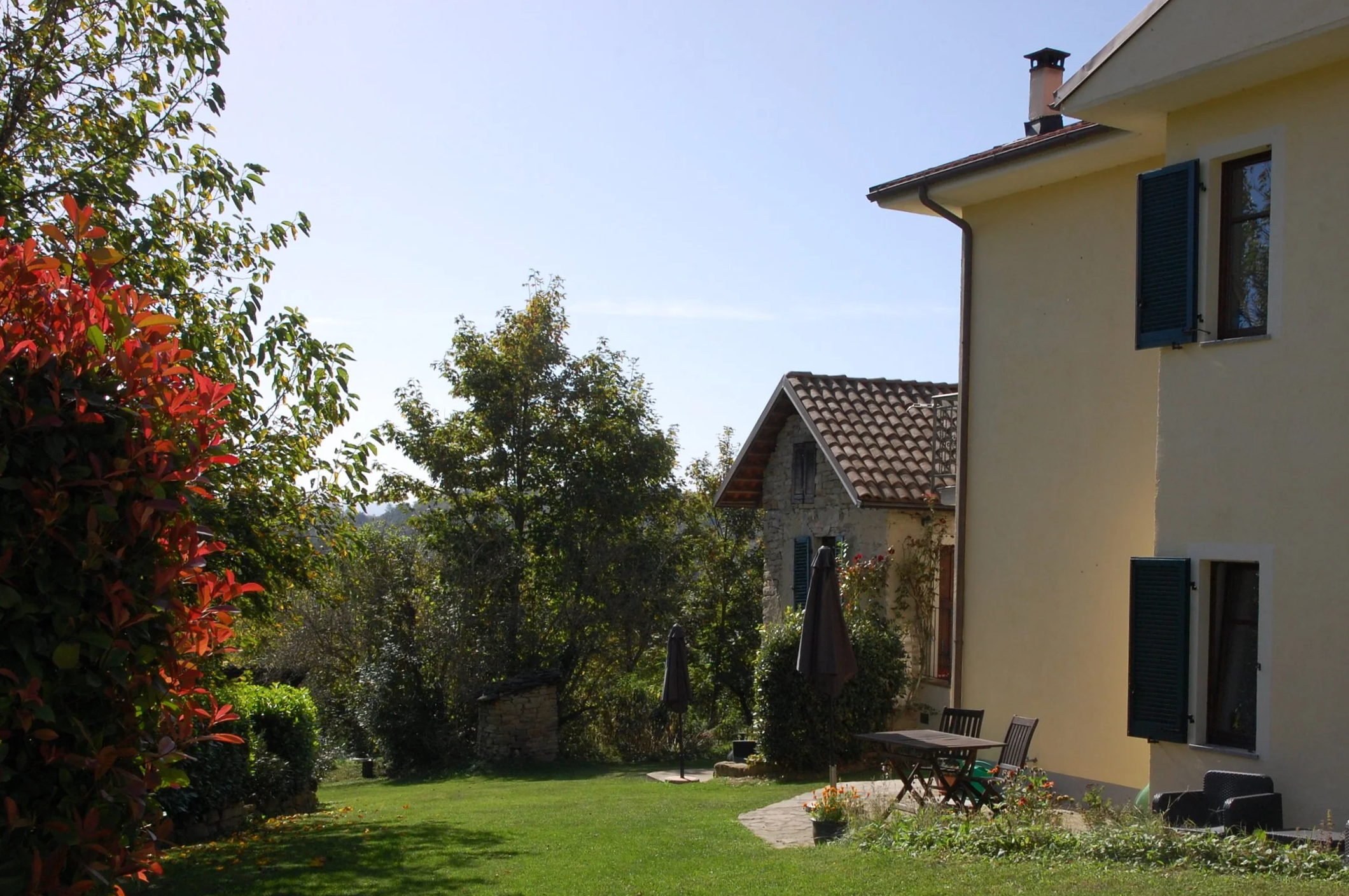 Tuin met rechts op voorgrond appartement Cinghiale en op de achtergrond huisje Capriolo