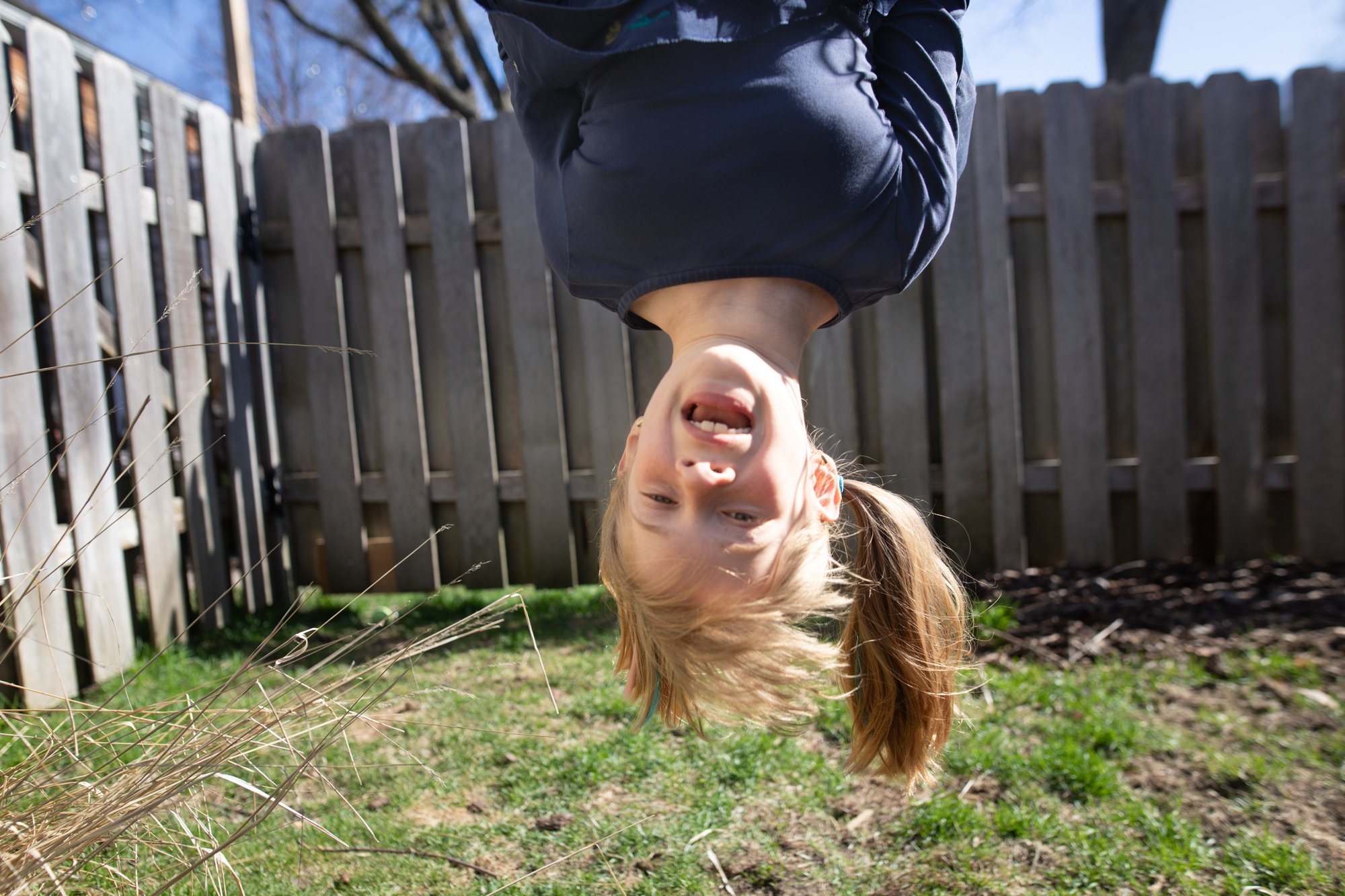 Giggling girl upside down on swingset