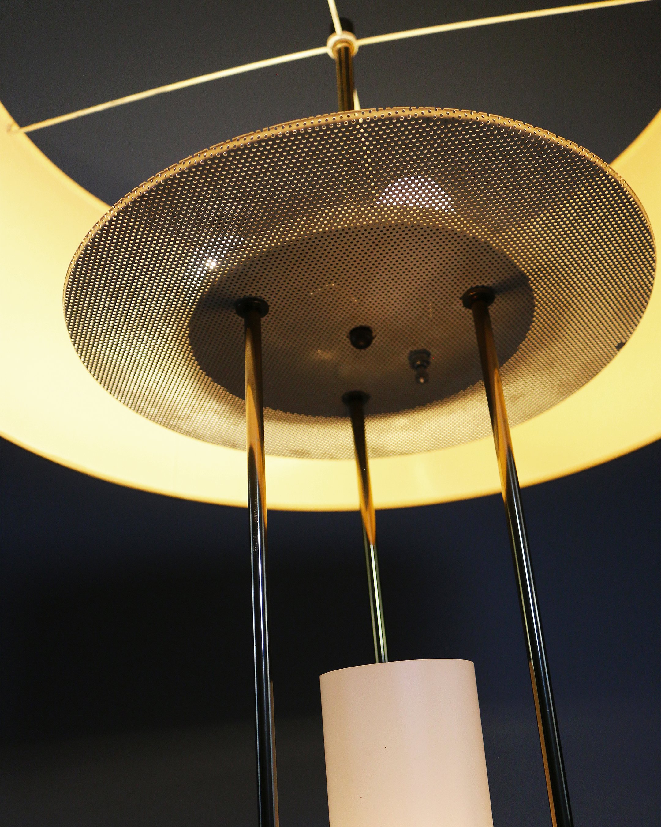 Side view of a 1950s mid-century modern floor lamp featuring a sleek brass frame and warm wood detailing.