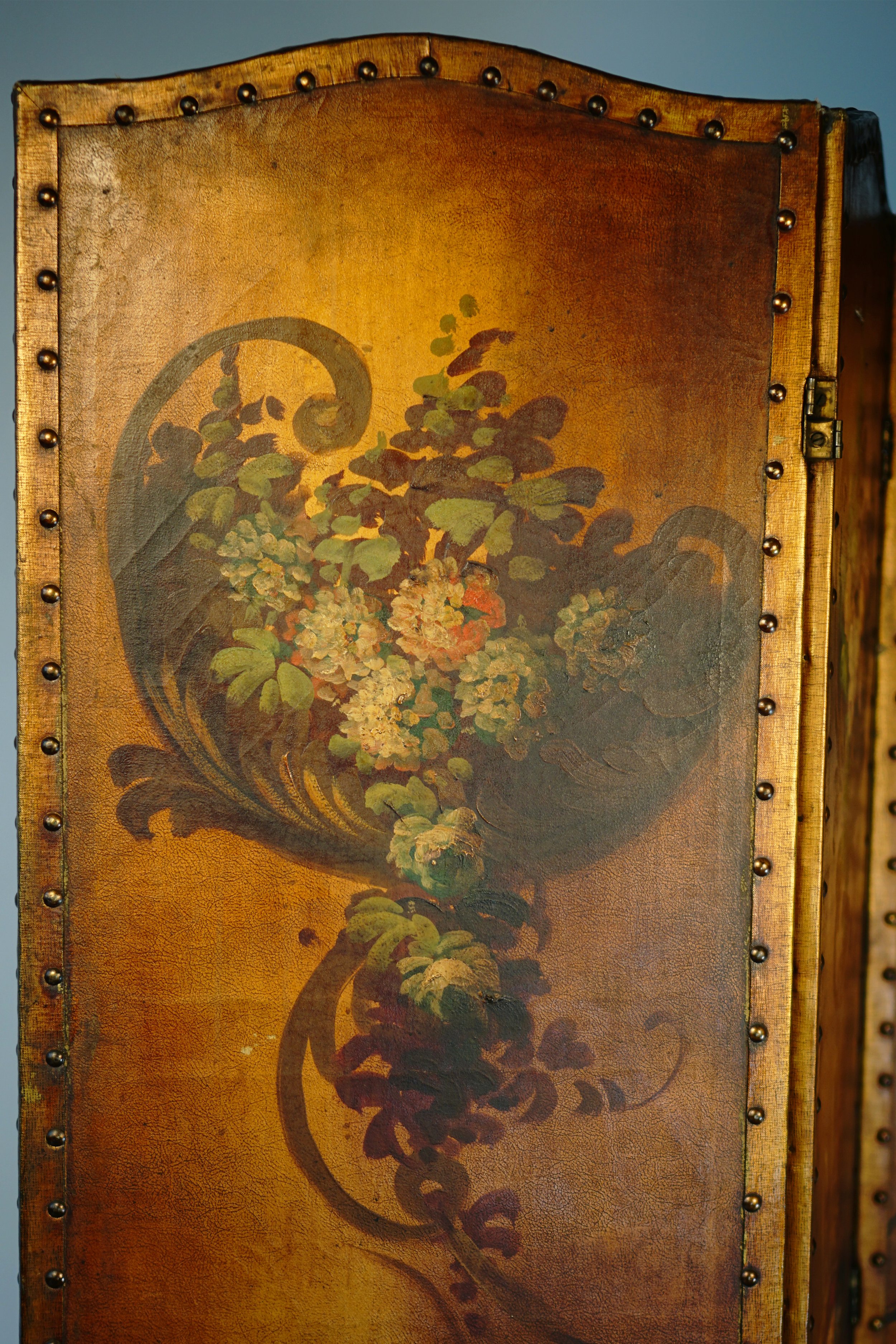 Antique Italian leather room divider with vintage floral painting and studded edges