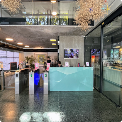 Recepción moderna de oficina con torniquetes y decoración contemporánea.