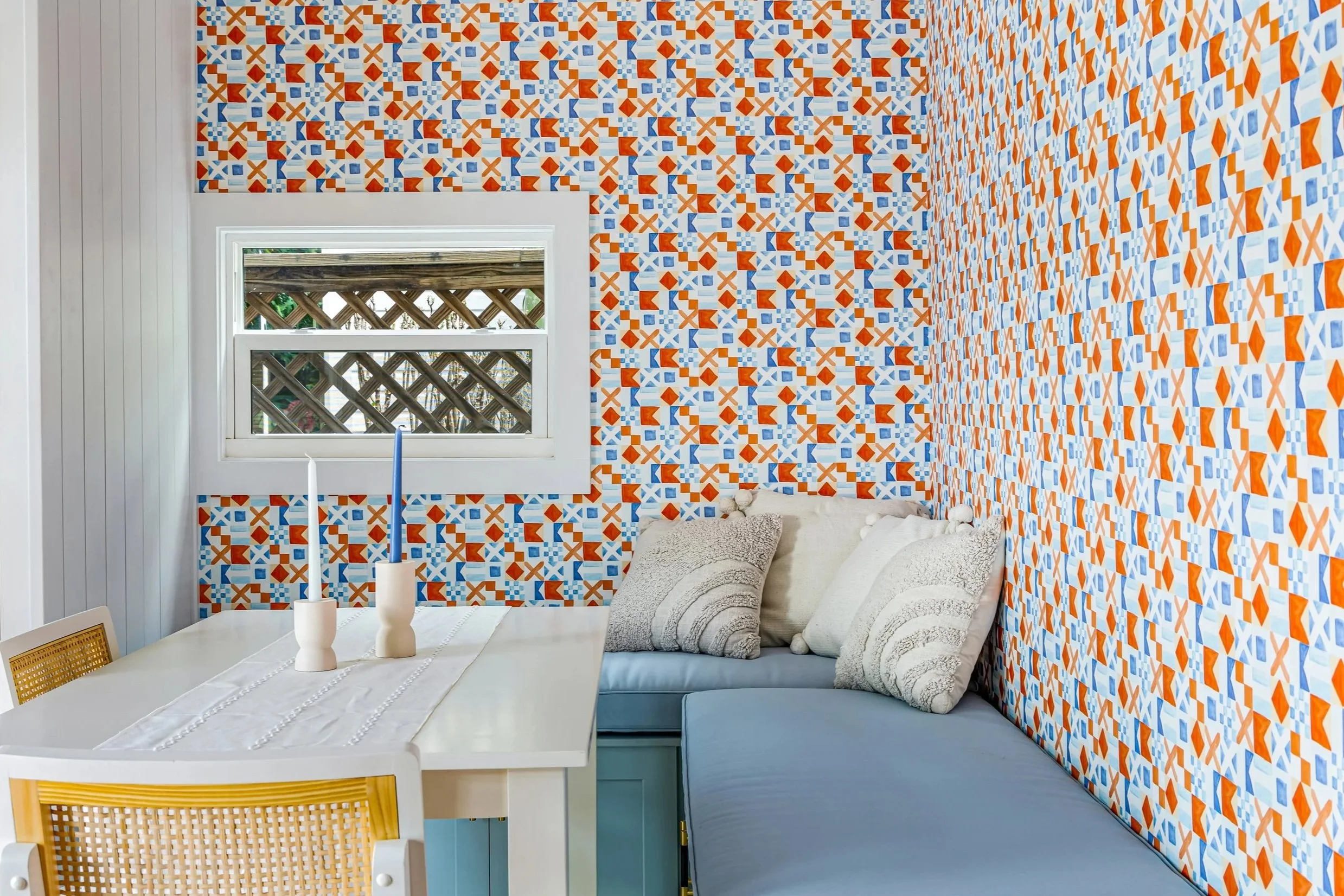 Dining Nook with geometric nautical flag wallpaper and blue cushions.