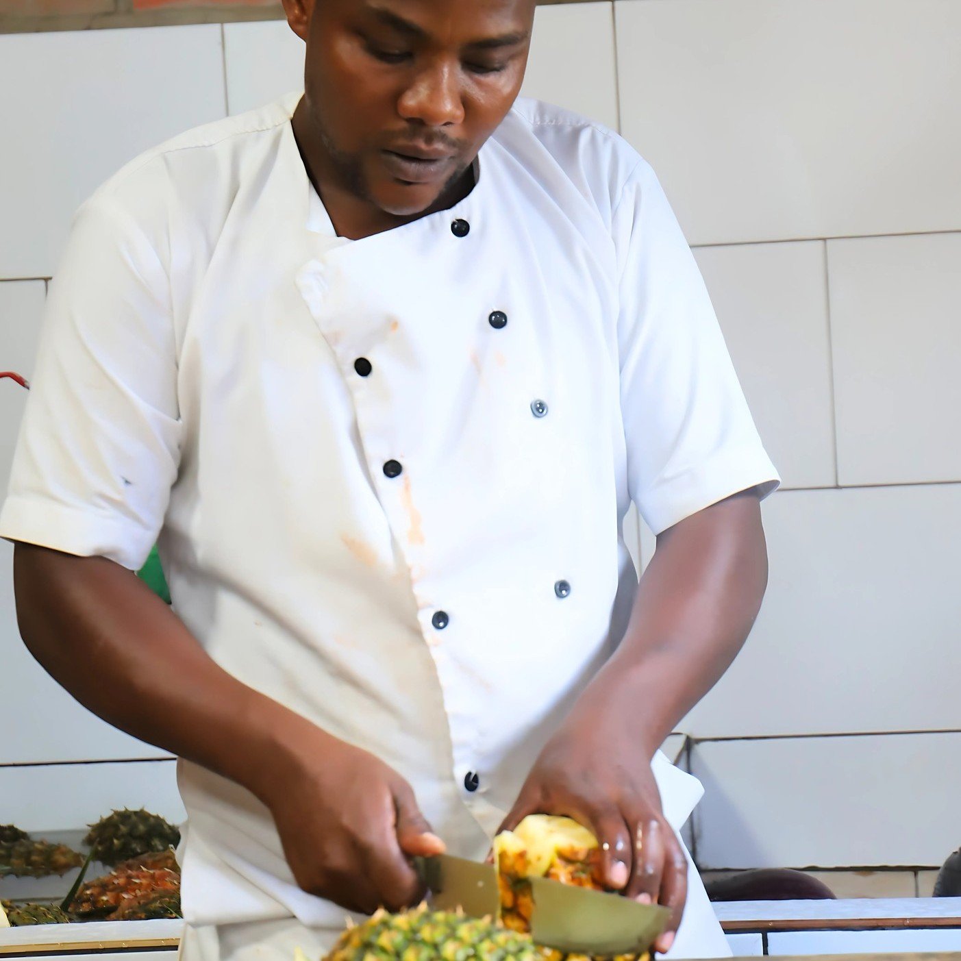 Happy Friday! Jean de Dieu Nshimiyimana, one of the chefs at RCCS, is slicing fresh pineapples that will be served as part of a nutritious lunch for our students today. He knows the pineapples are fresh because they were harvested just yesterday from
