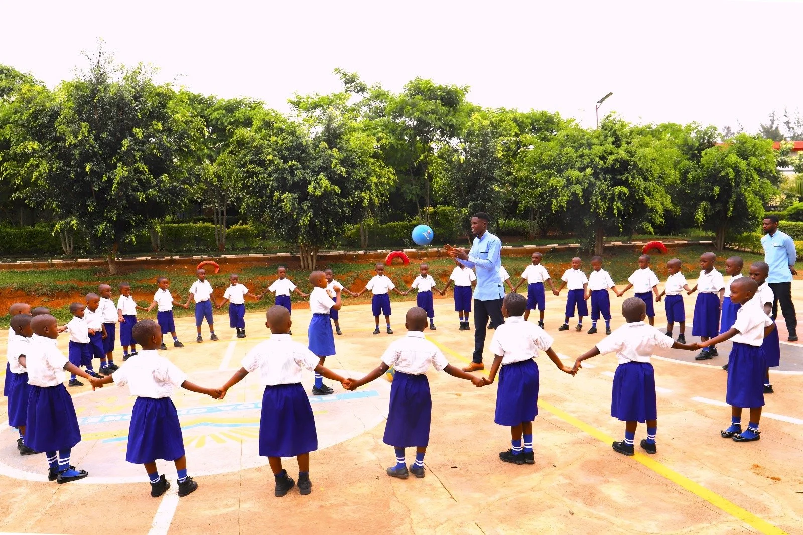 Aristophane Igiraneza, our RCCS Physical Education (PE) teacher, has this class of Primary students form a circle as they prepare to play a game. Our PE classes encompass a variety of activities, including traditional sports such as basketball and so