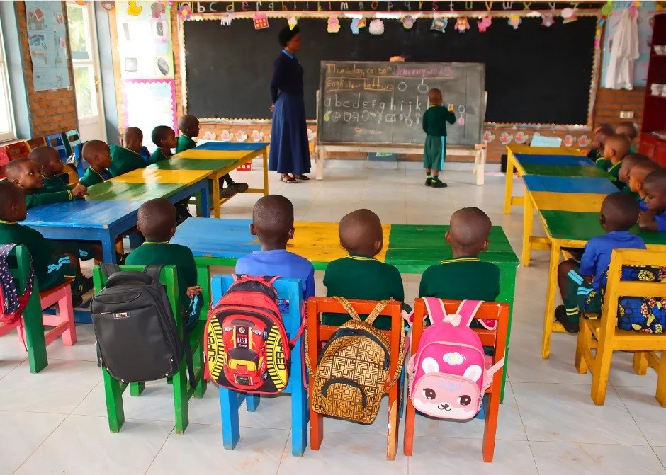 This class of Early Childhood Development students is practicing their ABCs. Their teacher is helping them practice letter recognition and sounds by drawing objects that start with each letter on the board. Children typically learn the alphabet throu